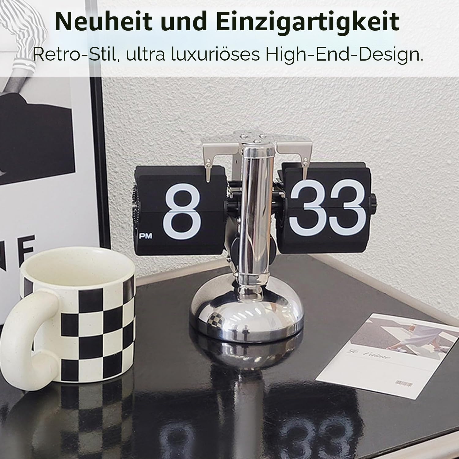 Retro-Klappzahlenuhr aus Metall mit weißem und schwarzem Design neben einem karierten Becher auf schwarzem Tisch.