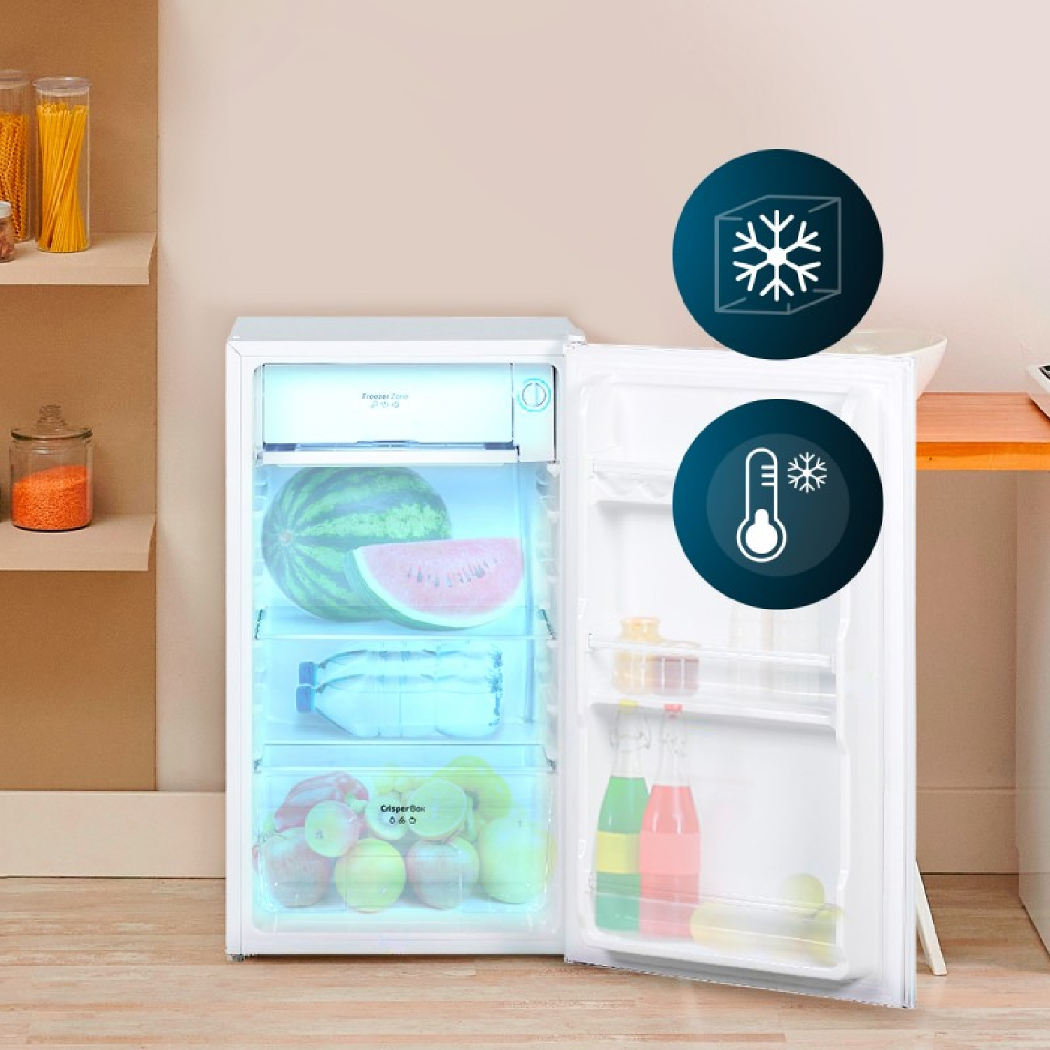 Un mini frigo bianco con la porta aperta, pieno di anguria, bottiglie e frutta nel cassetto verdura.