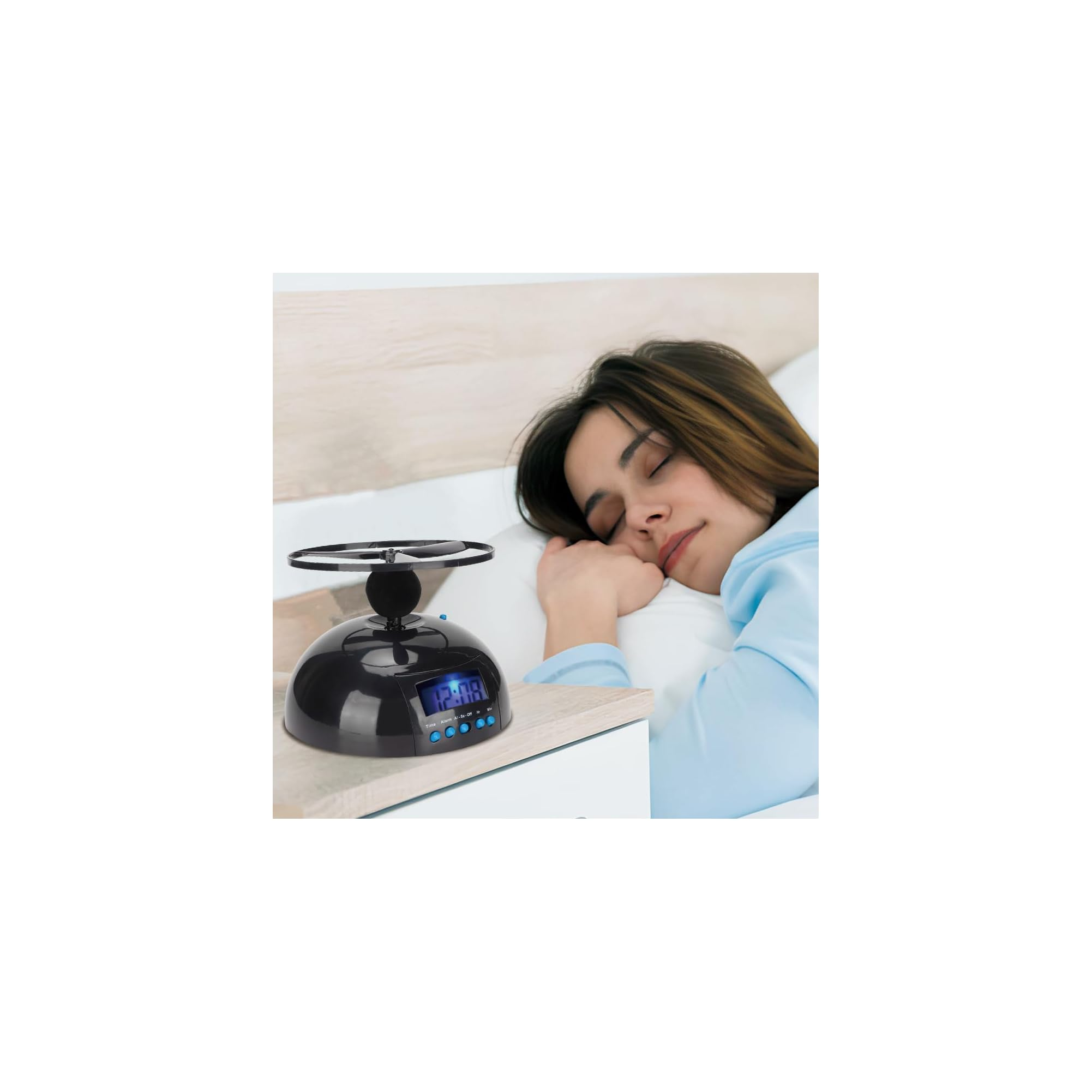Eine Frau schläft im Bett neben einem schwarzen fliegenden Wecker auf dem Nachttisch.