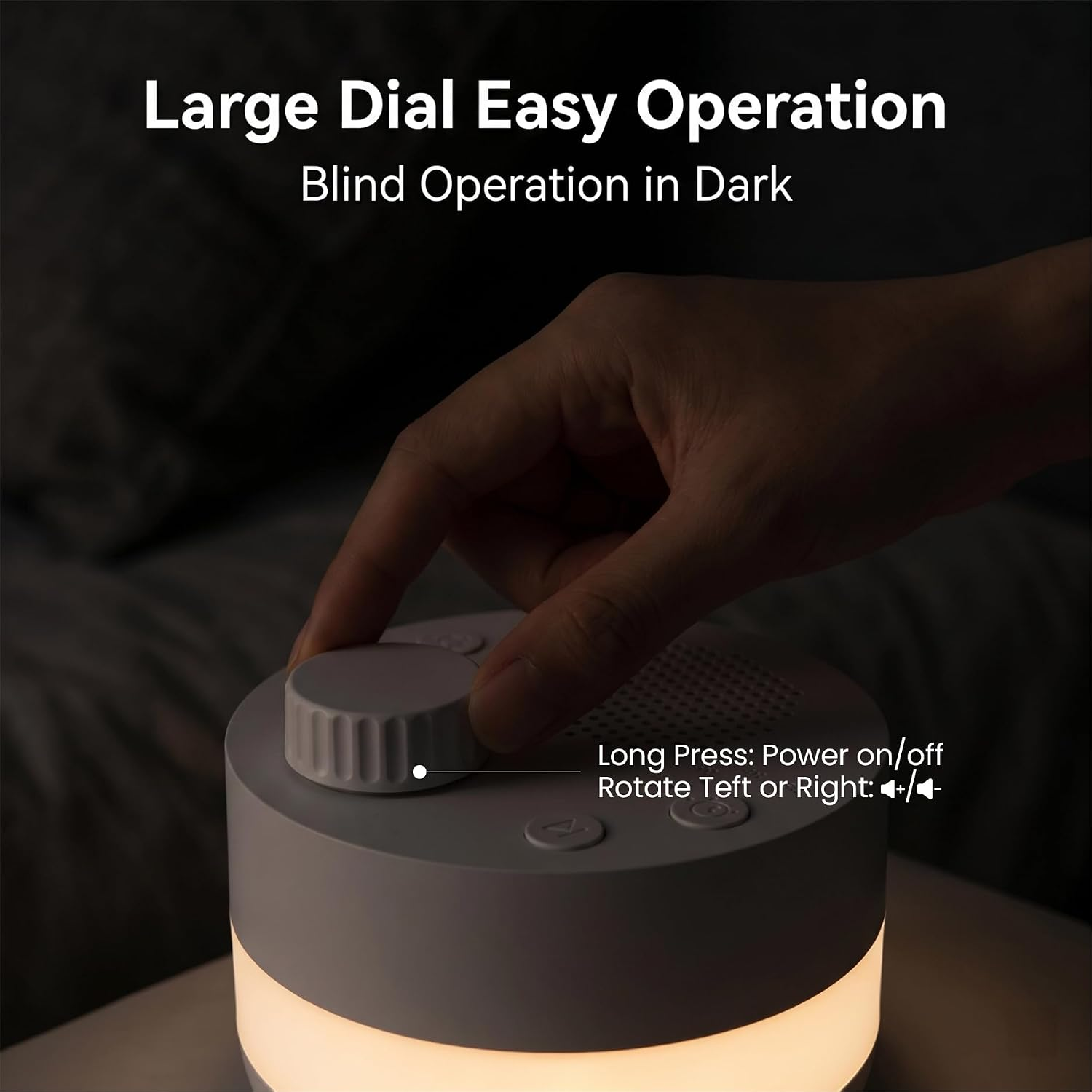 Eine Hand verstellt das große Rad an einer weißen, zylindrischen Nachttischlampe mit leuchtendem Sockel.