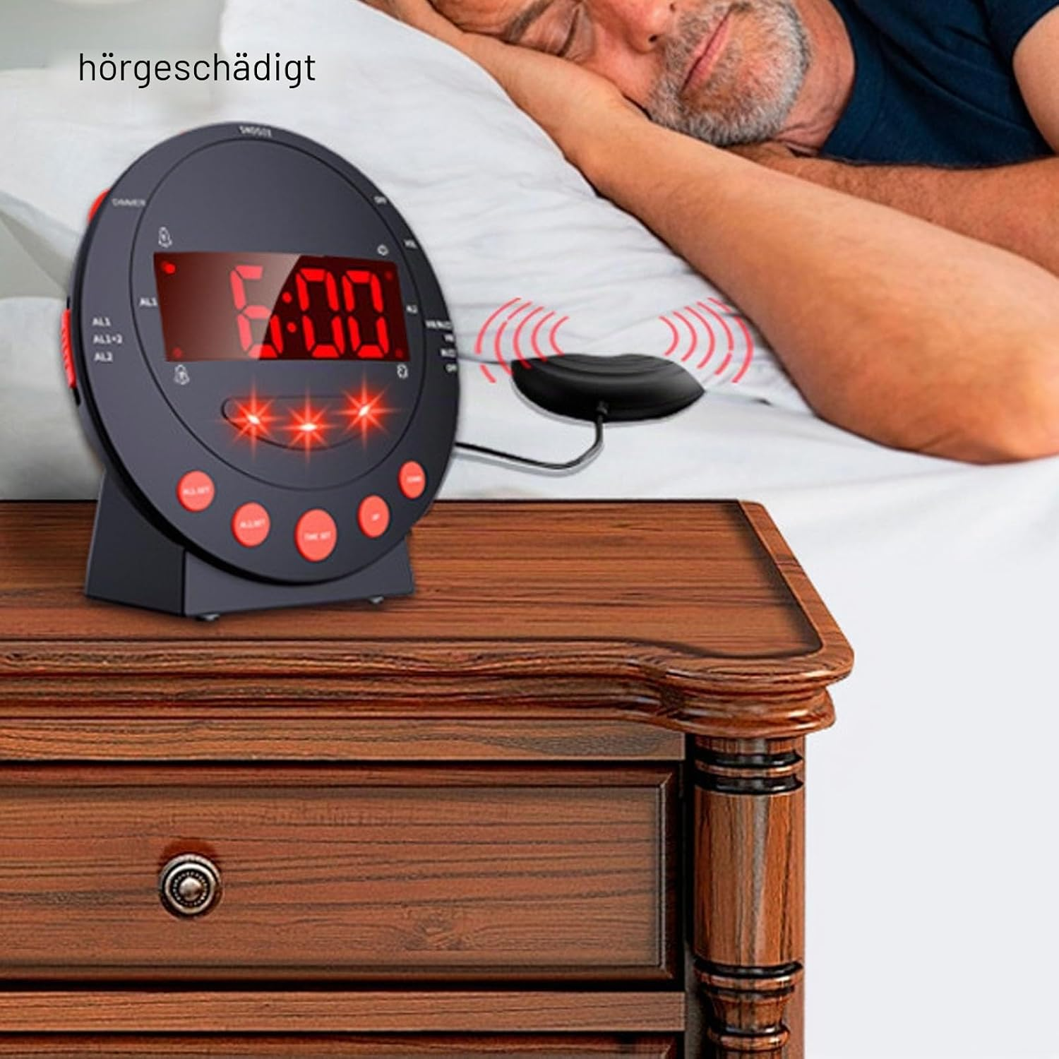 Ein schwarzer Wecker mit rotem Display steht auf einem Nachttisch, während im Hintergrund eine Person schläft.