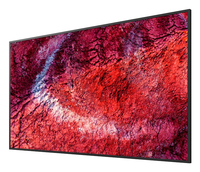 Un téléviseur sans cadre affiche une image colorée de sol craquelé rouge et violet.