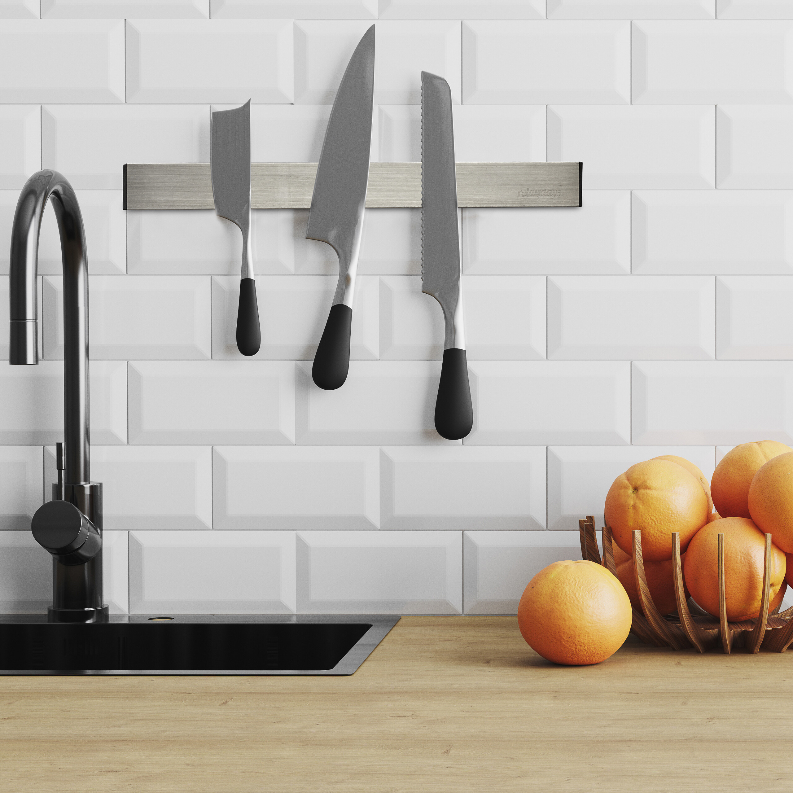 Drei Messer hängen an einer Magnetleiste über einer Holztheke mit Orangenschale und schwarzem Wasserhahn.