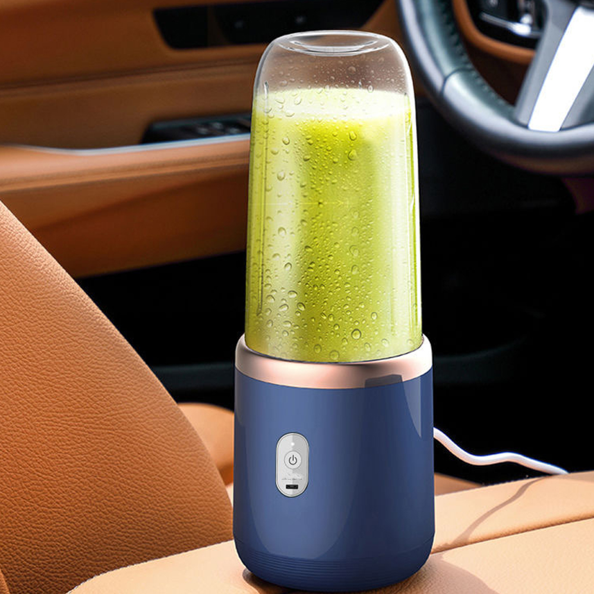 Ein blauer tragbarer Mixer mit grünem Smoothie in einem Auto.