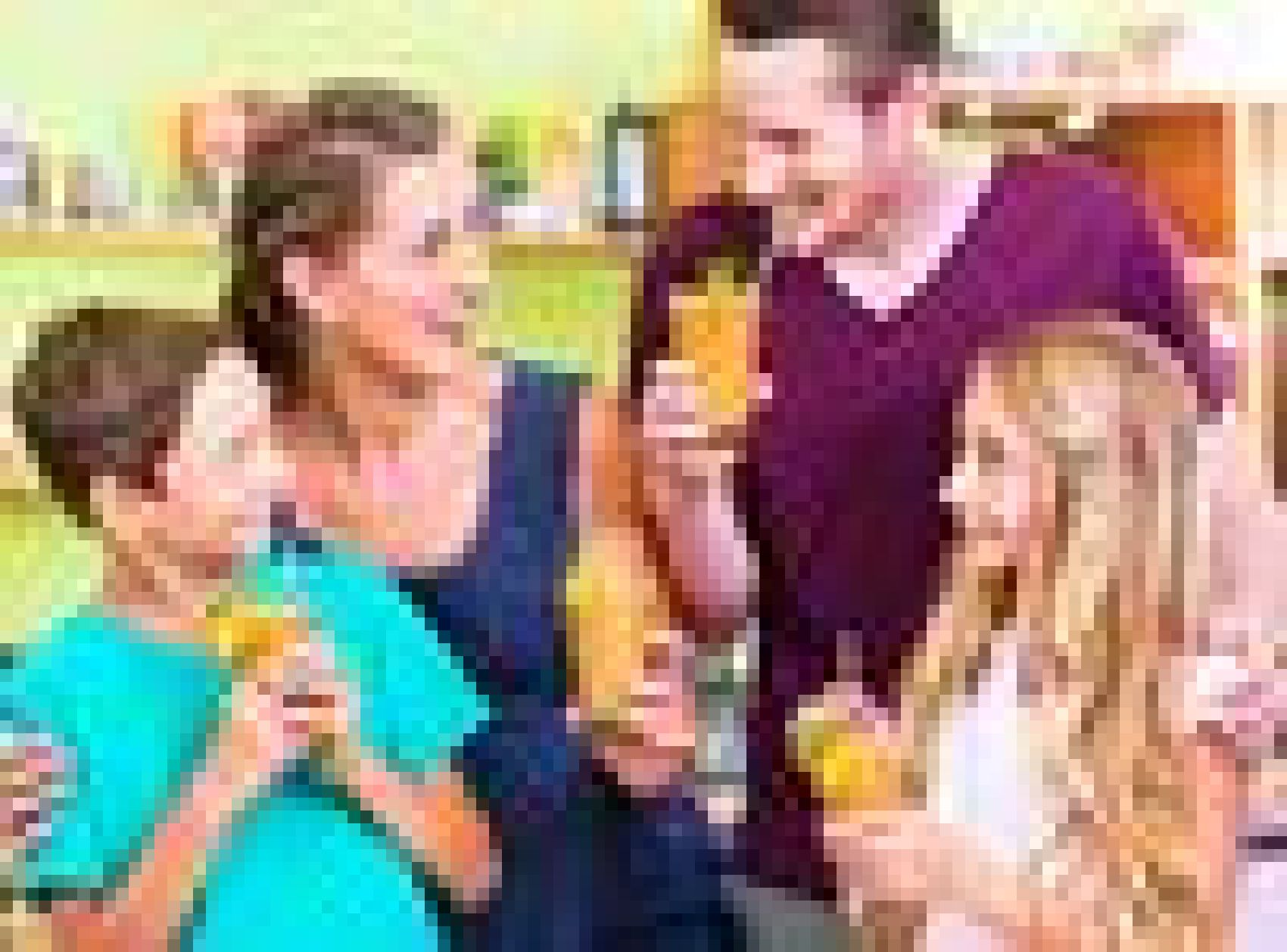 Eine vierköpfige Familie hält glücklich Gläser mit Saft in einer hellen Küche.