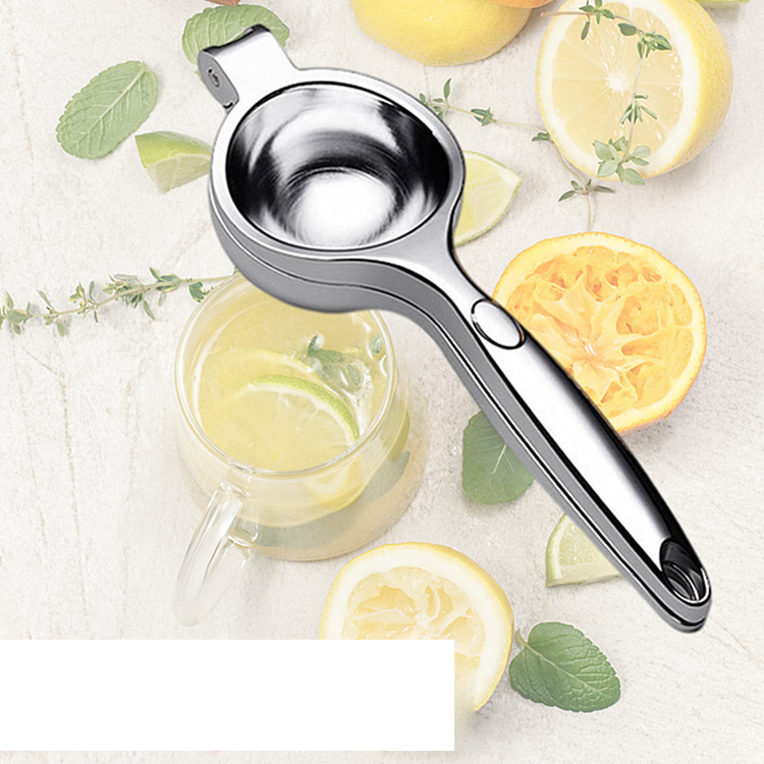 Eine Zitronenpresse aus Metall liegt auf einem Tisch, umgeben von Zitronen, Limetten, Kräutern und einem Glas Saft.