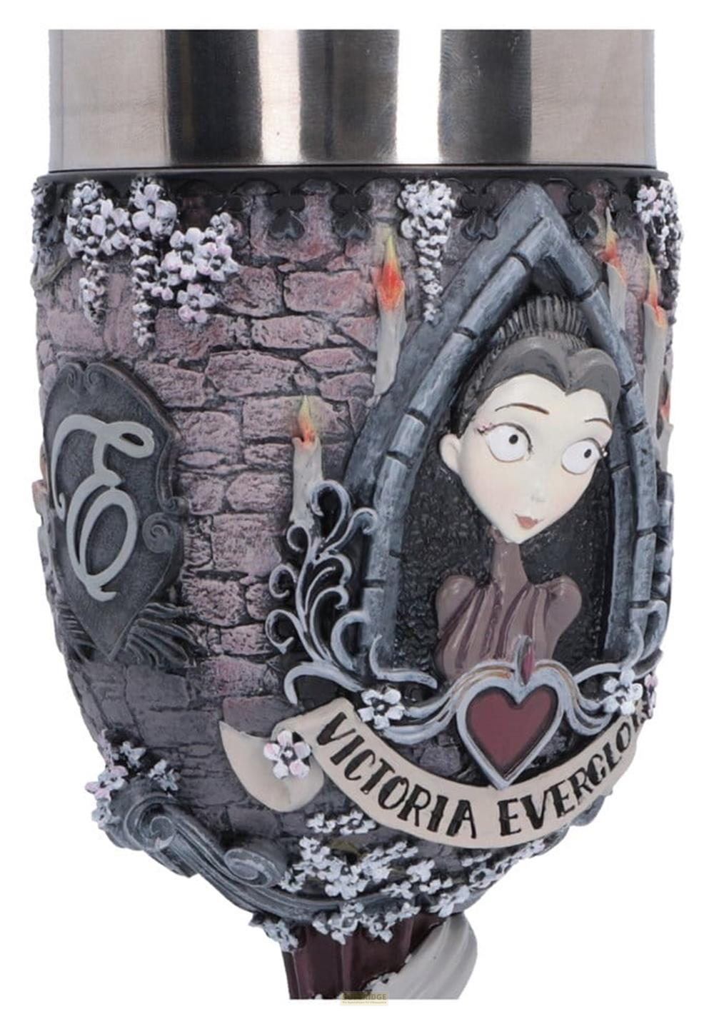 Verzierter Kelch mit Victoria Everglot-Figur, Kerzen und Steinmauer.