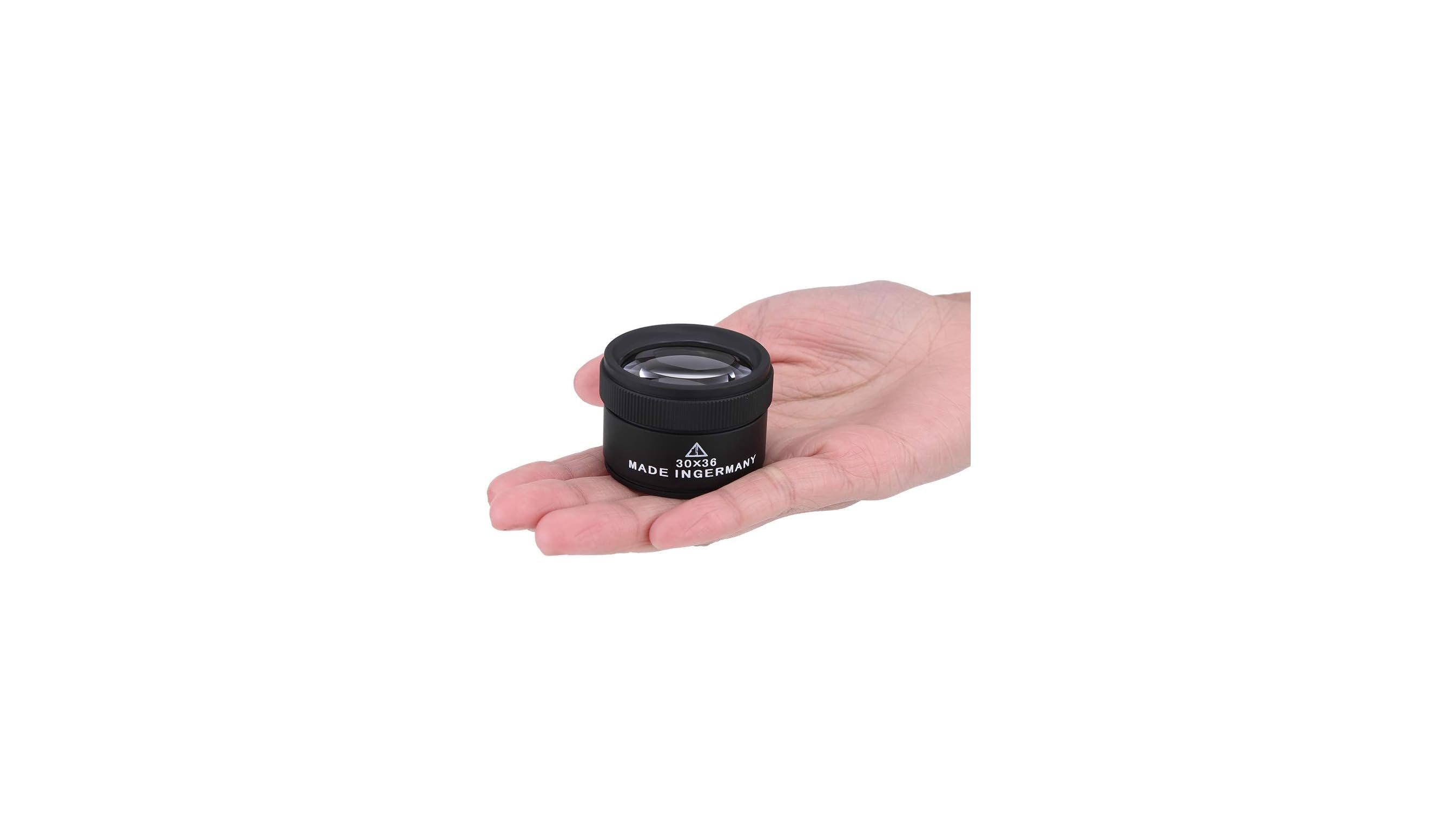 Eine offene Hand hält eine kleine schwarze Lupenlinse mit weißem Aufdruck auf weißem Hintergrund.