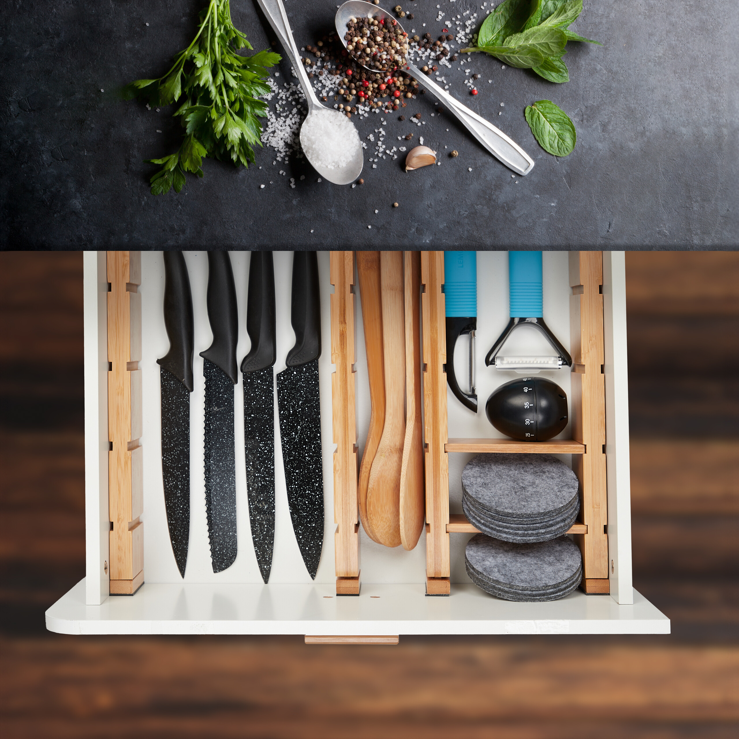 Geöffnete Küchenschublade mit Messern, Holzlöffeln, Sparschälern und Untersetzern; darüber Kräuter und Gewürze.