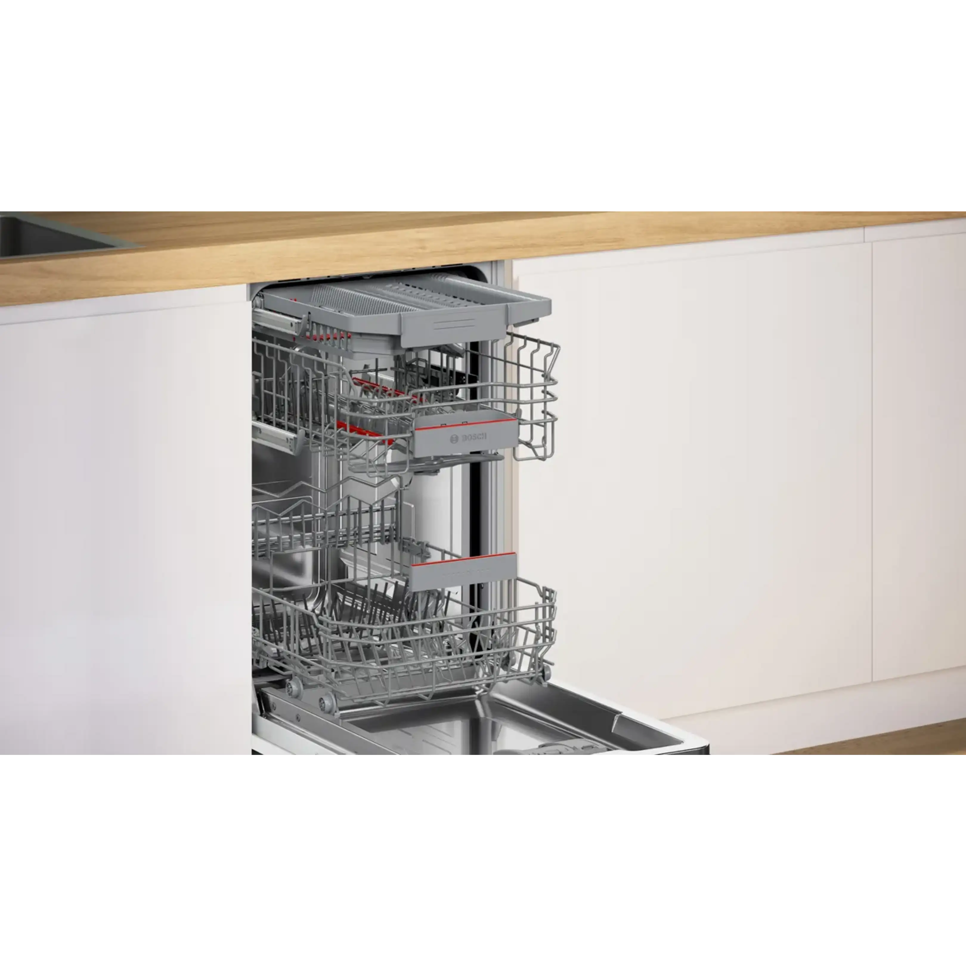 Lavastoviglie incassata aperta con cestelli grigi vuoti in una cucina bianca moderna con piano in legno.