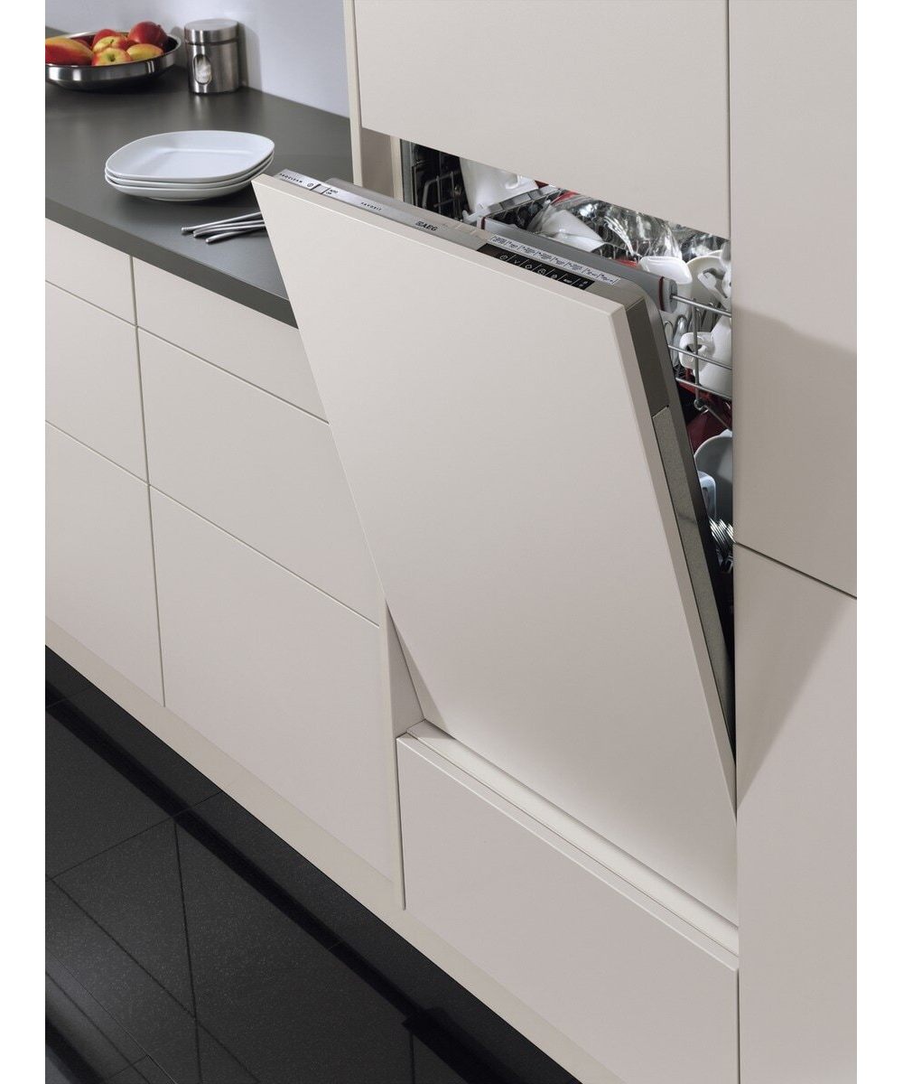 Una lavastoviglie integrata aperta in una cucina luminosa con pavimento scuro.