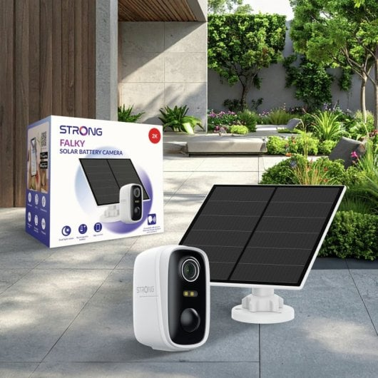Una telecamera di sicurezza bianca e un pannello solare su pavimento in pietra con scatola e giardino sullo sfondo.