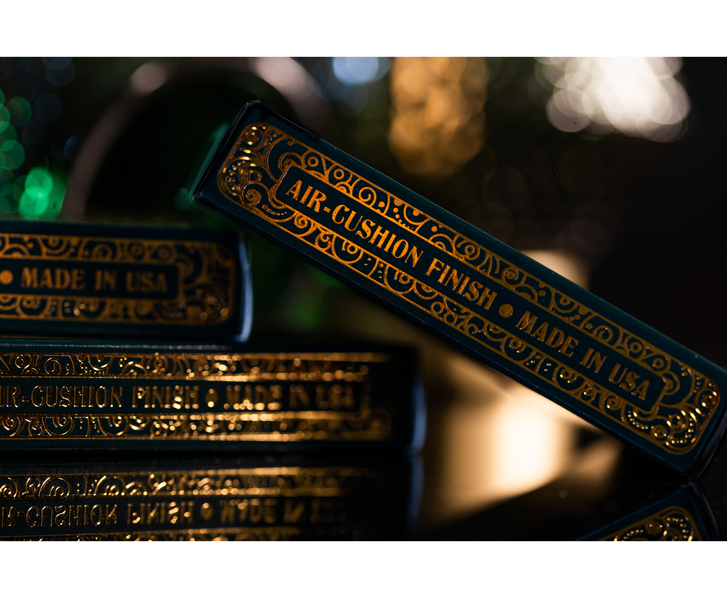 Dunkelgrüne Spielkartenpackungen mit goldener Prägung und der Aufschrift AIR-CUSHION FINISH MADE IN USA.