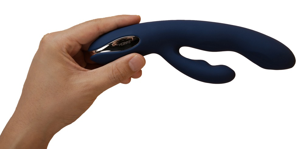 Eine Hand hält einen dunkelblauen, geschwungenen Vibrator mit silbernen Details vor weißem Hintergrund.