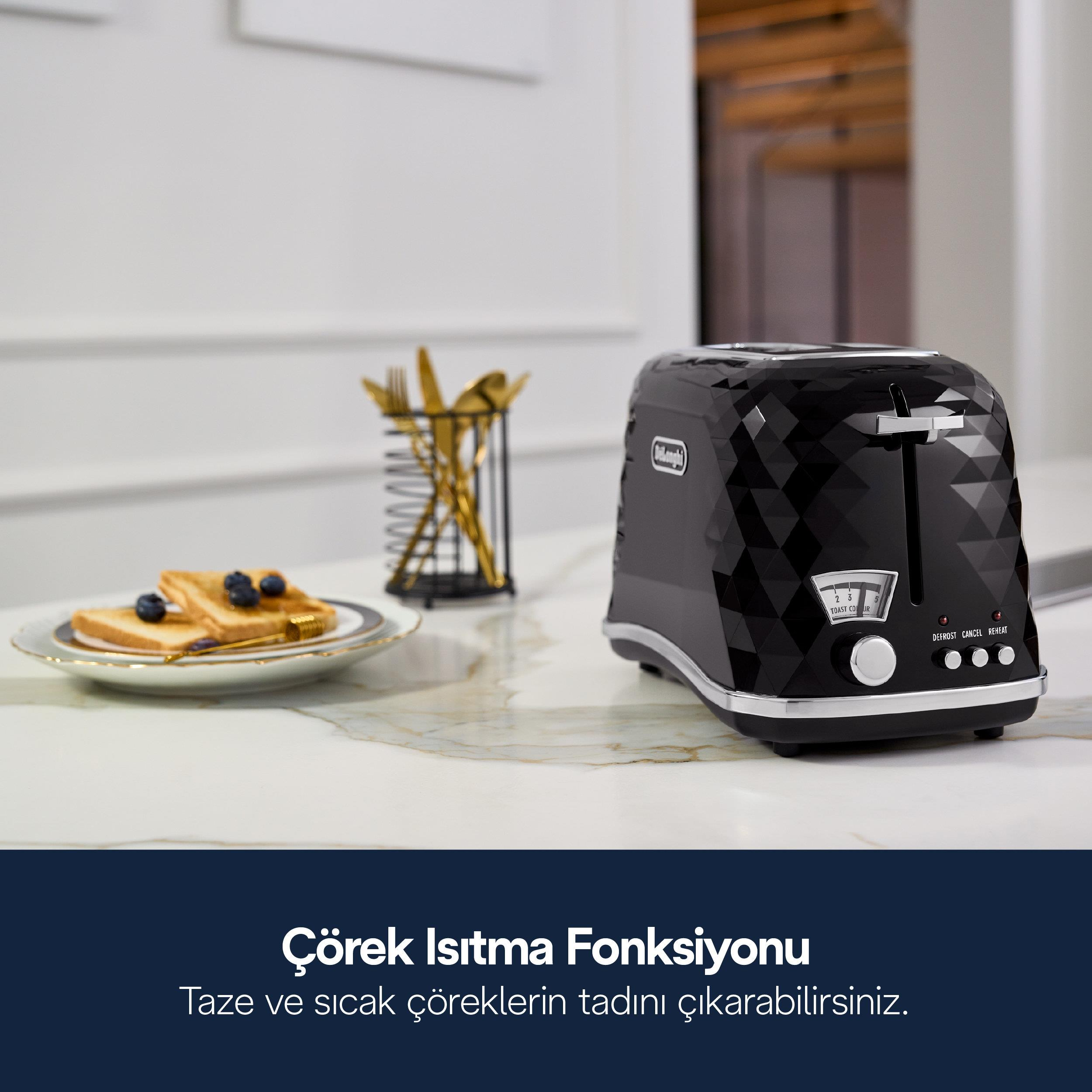 Mermer tezgah üzerinde siyah, yönlü bir ekmek kızartma makinesi ve arkada tost ve yaban mersini.