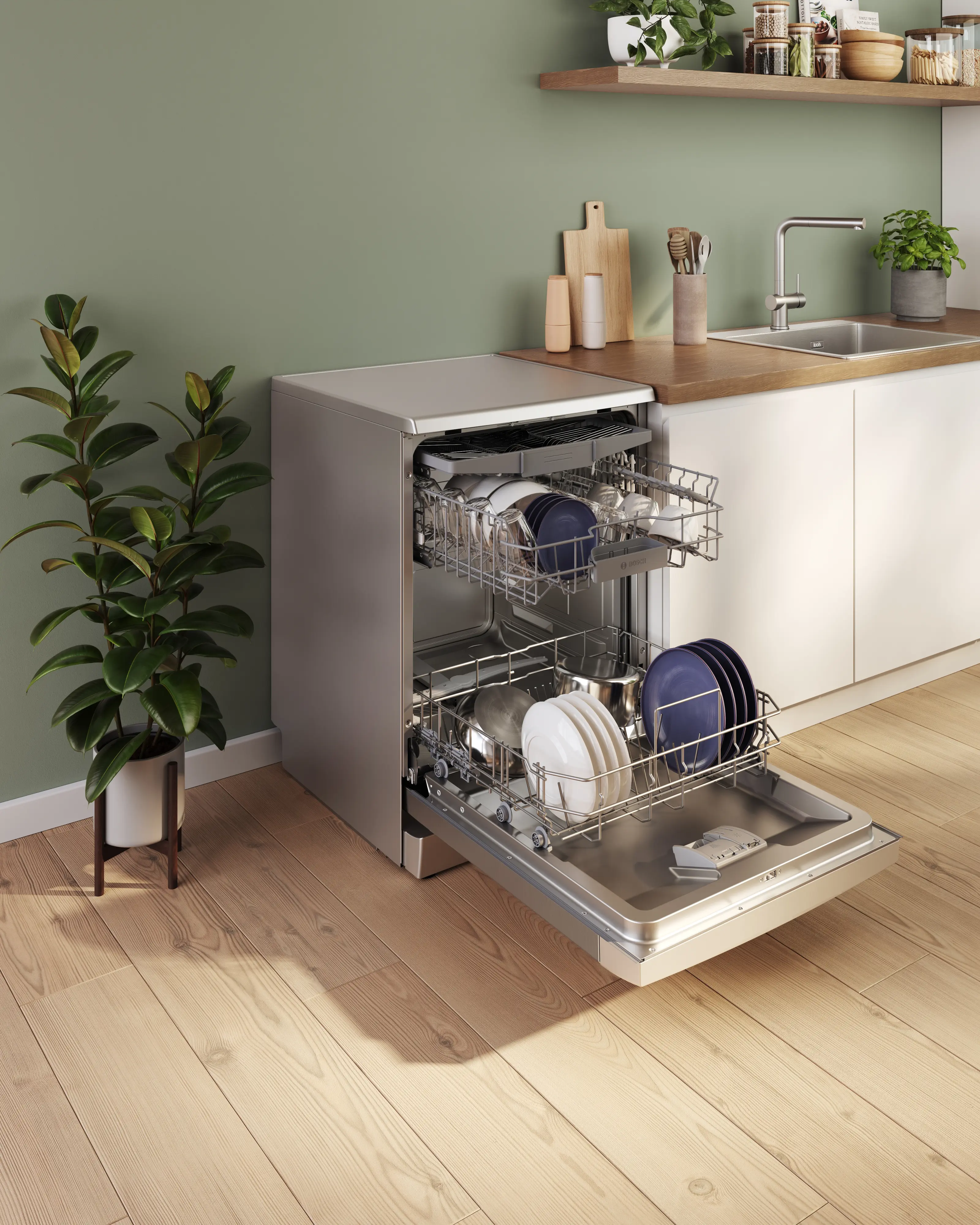 Una lavastoviglie aperta in una cucina moderna con pavimento in legno e parete verde.