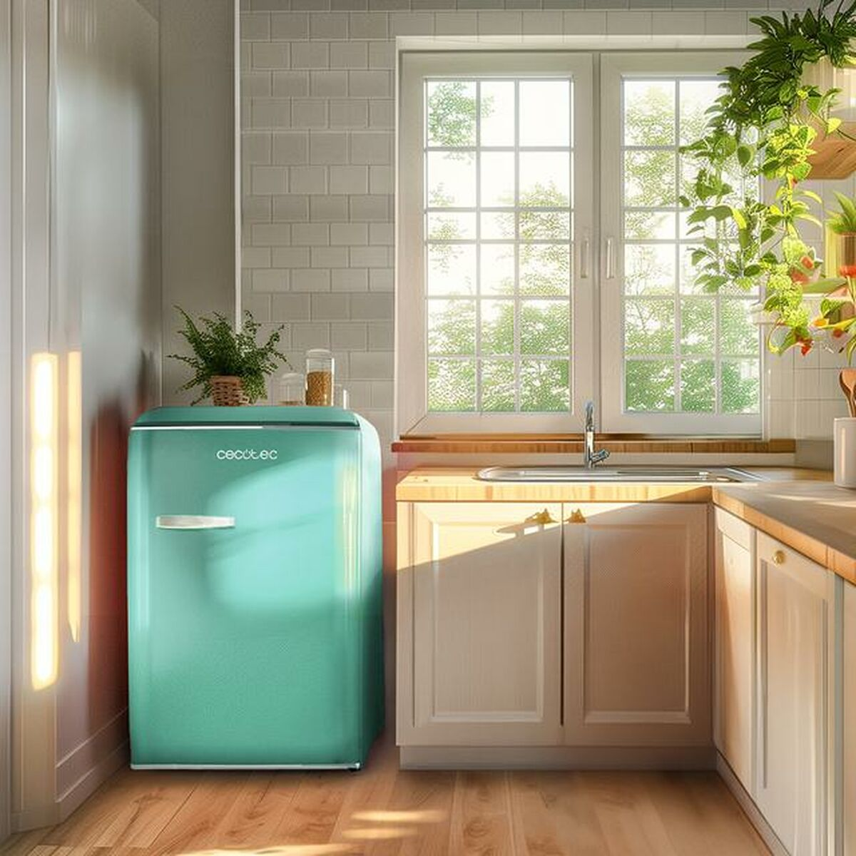 Ein mintgrüner Retro-Kühlschrank steht in einer sonnigen Küche mit hellen Holzmöbeln, Pflanzen und weißem Wandfliesenspiegel.