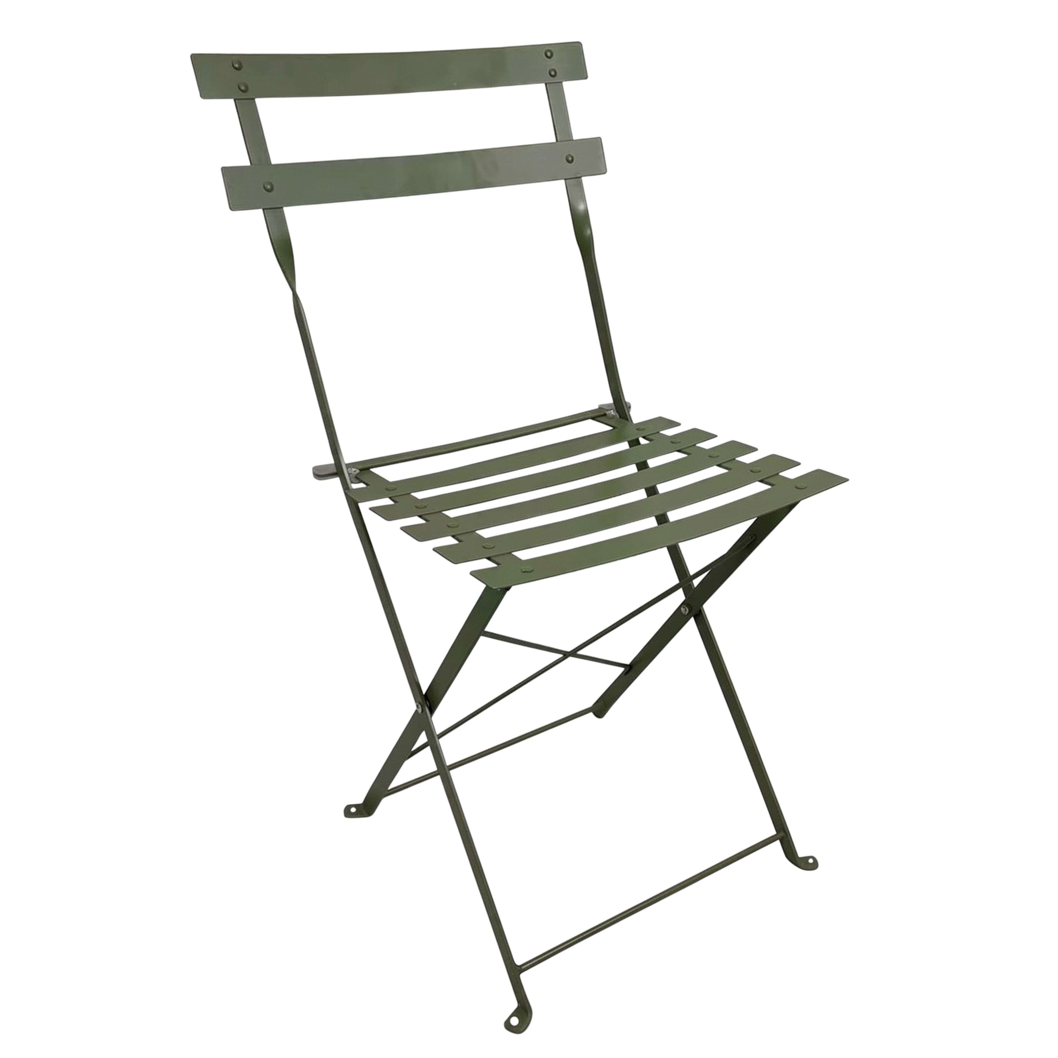 Una silla plegable de metal verde con listones en el asiento y el respaldo sobre fondo blanco.