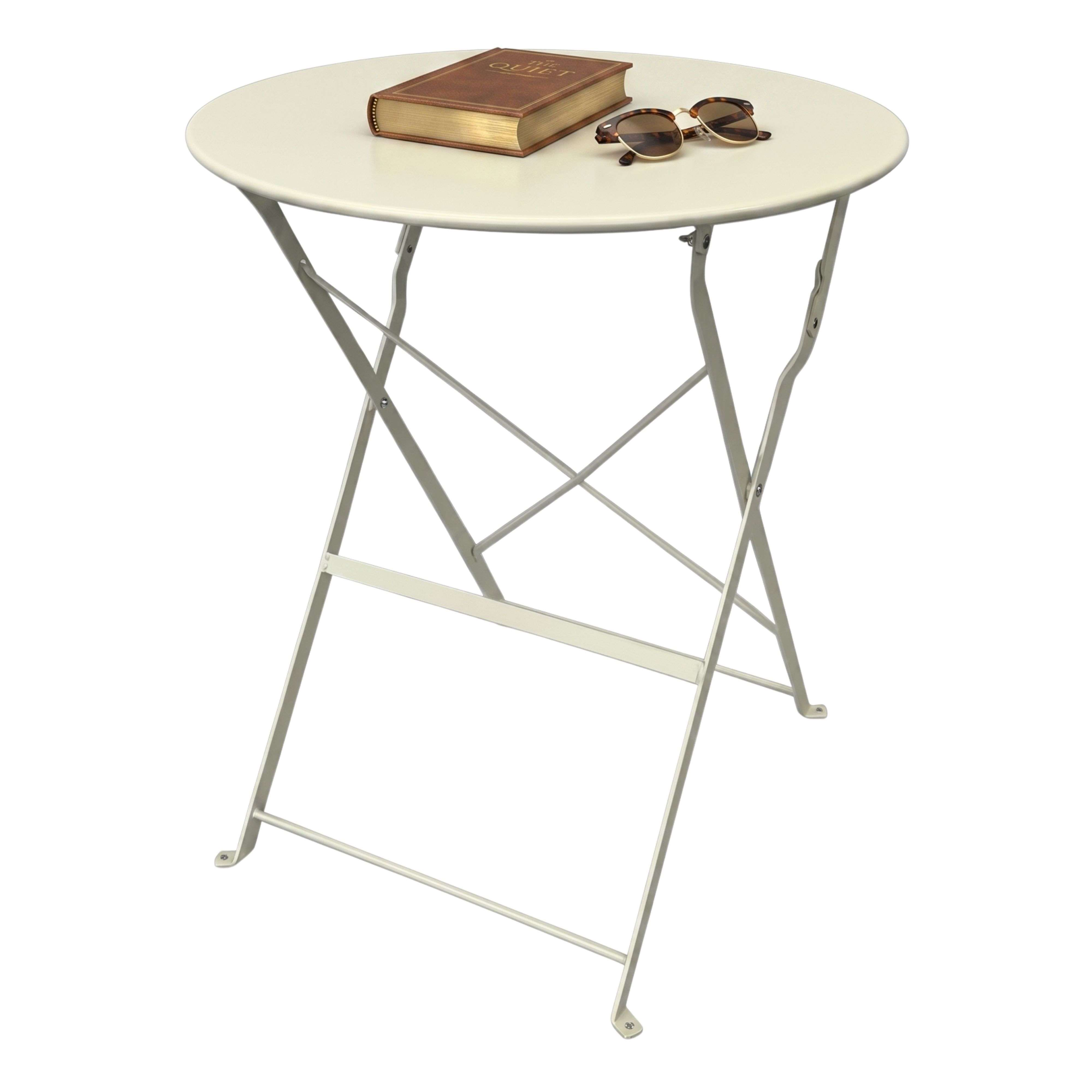 Una mesa plegable redonda beige con patas cruzadas sobre fondo blanco, con un libro y gafas de sol encima.