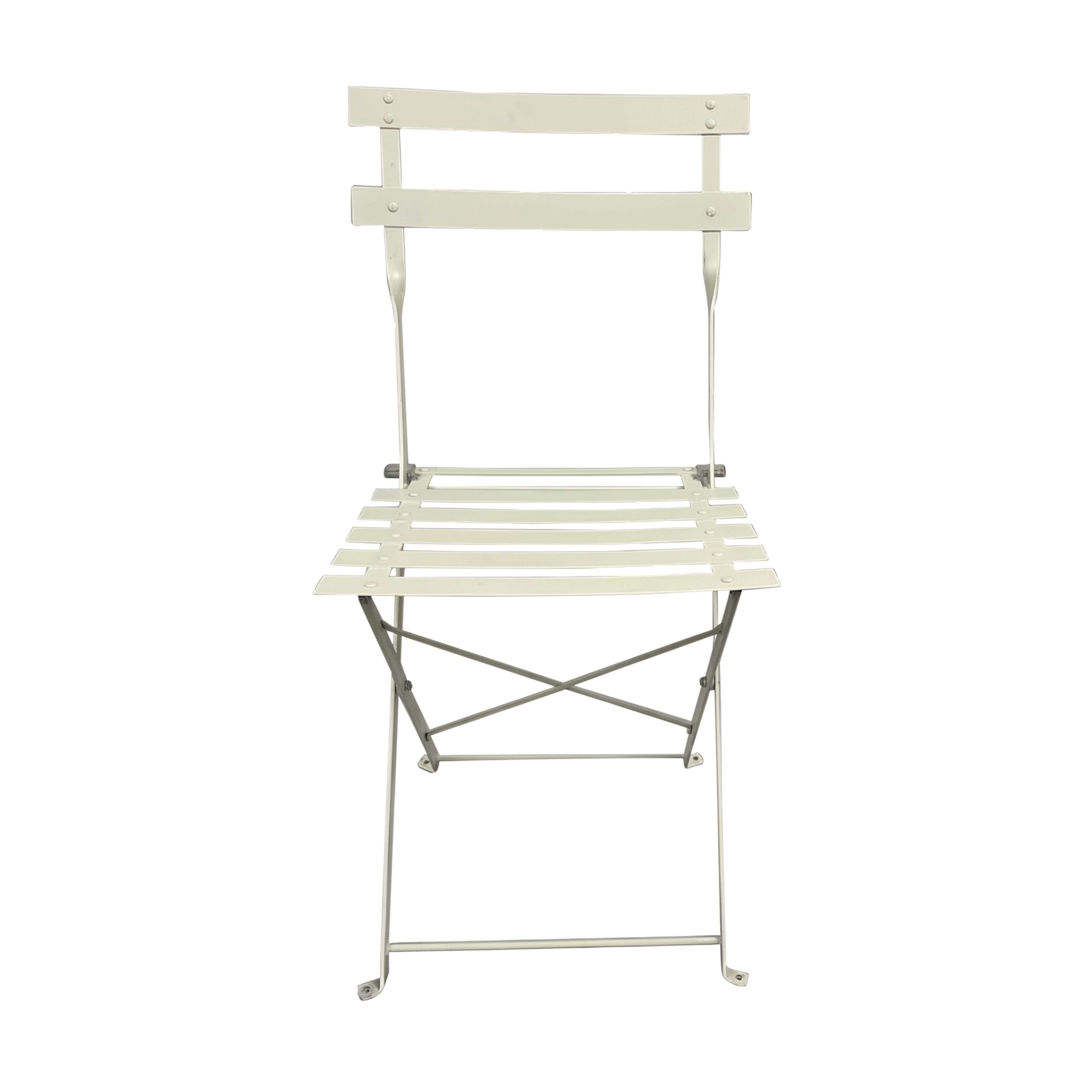 Una silla plegable de metal blanco con asiento y respaldo de listones sobre fondo blanco.