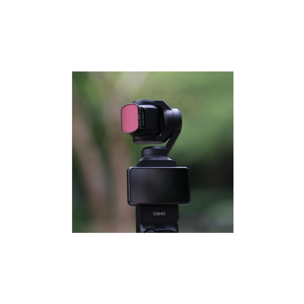 Una telecamera Osmo nera con un filtro rosa sull'obiettivo, su uno sfondo verde sfocato.