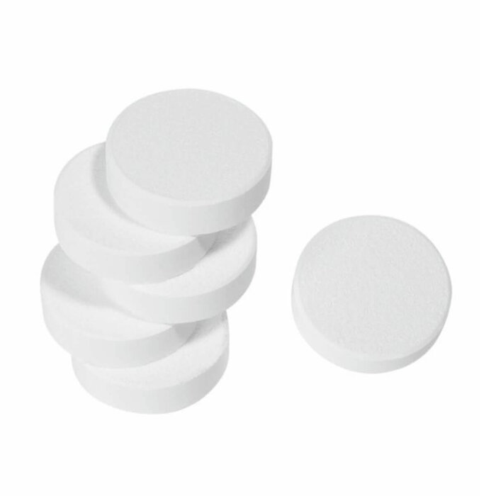 A stack of five round, white tablets and a single separate tablet next to it on a white background.