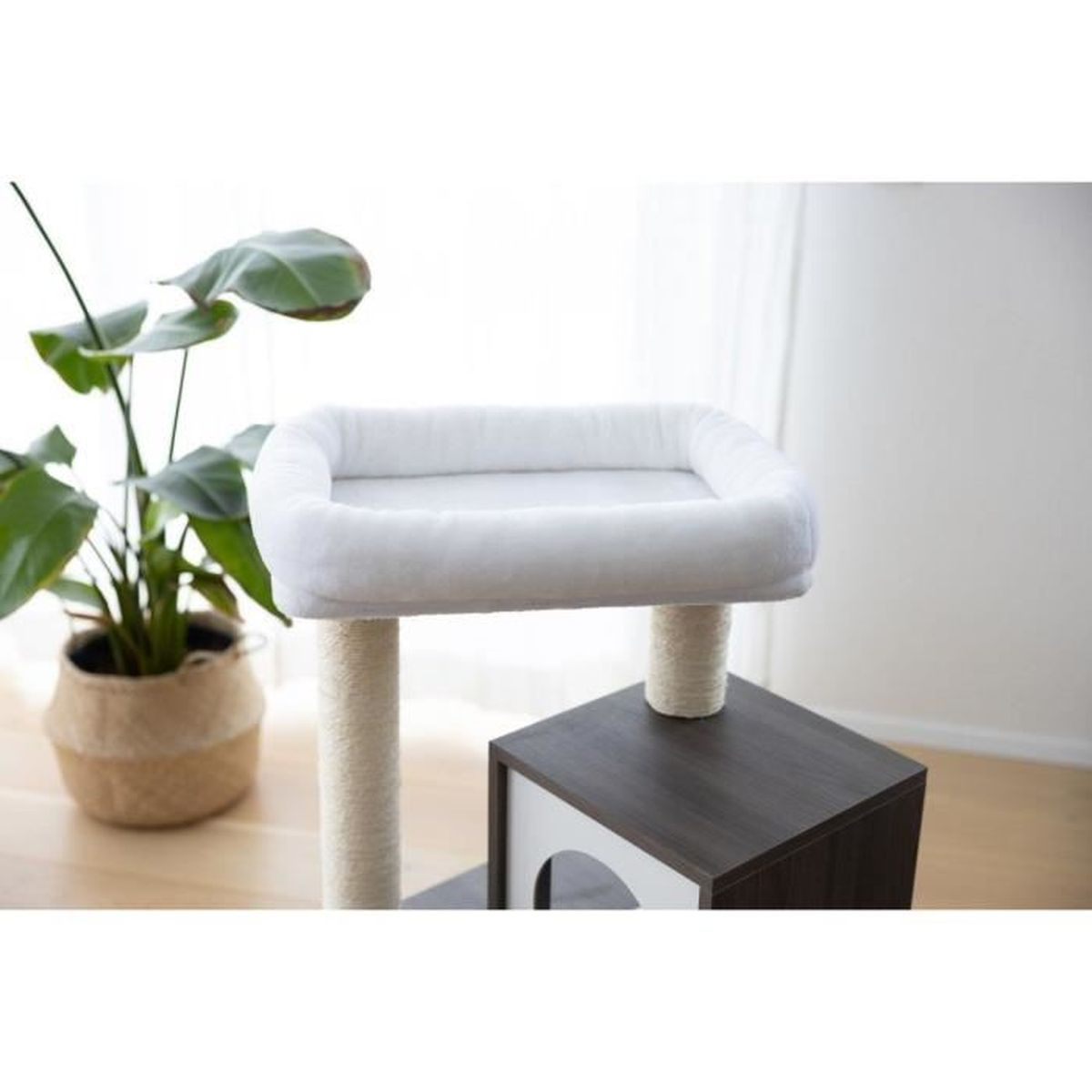 Un tiragraffi chiaro con letto in peluche bianco, pali in sisal e casetta in legno scuro.