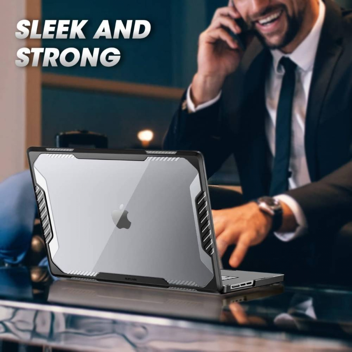 Ein Mann im Anzug nutzt einen Laptop mit Schutzhülle und telefoniert im Büro.