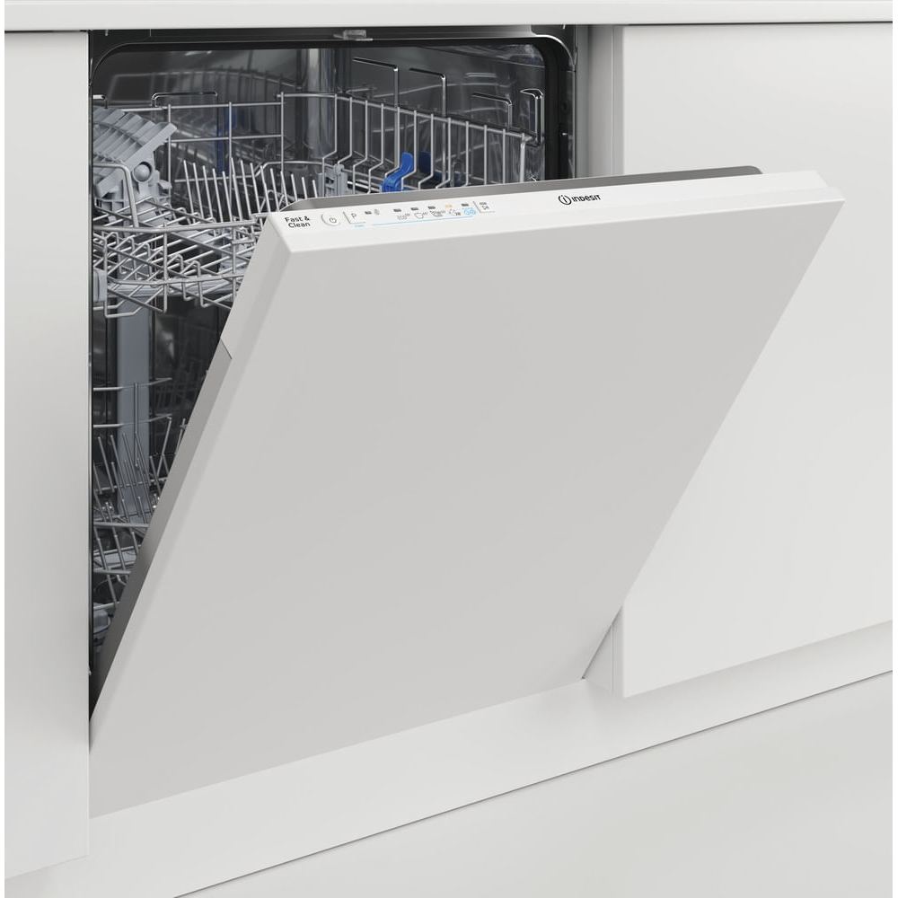 Una lavastoviglie bianca con la porta aperta è integrata in un mobile da cucina, mostrando i cestelli metallici interni.