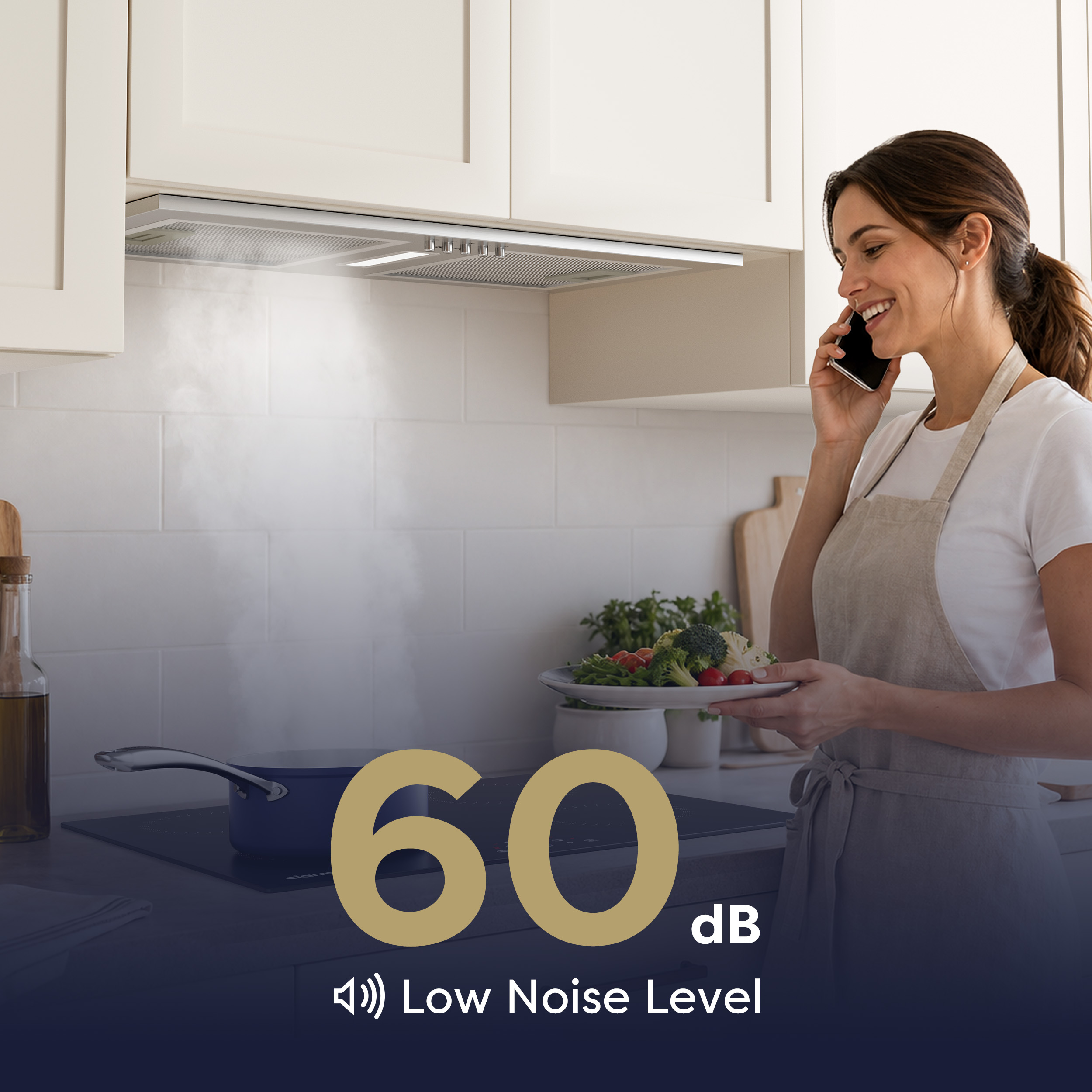 Una donna cucina in una cucina moderna con cappa aspirante mentre parla al telefono.