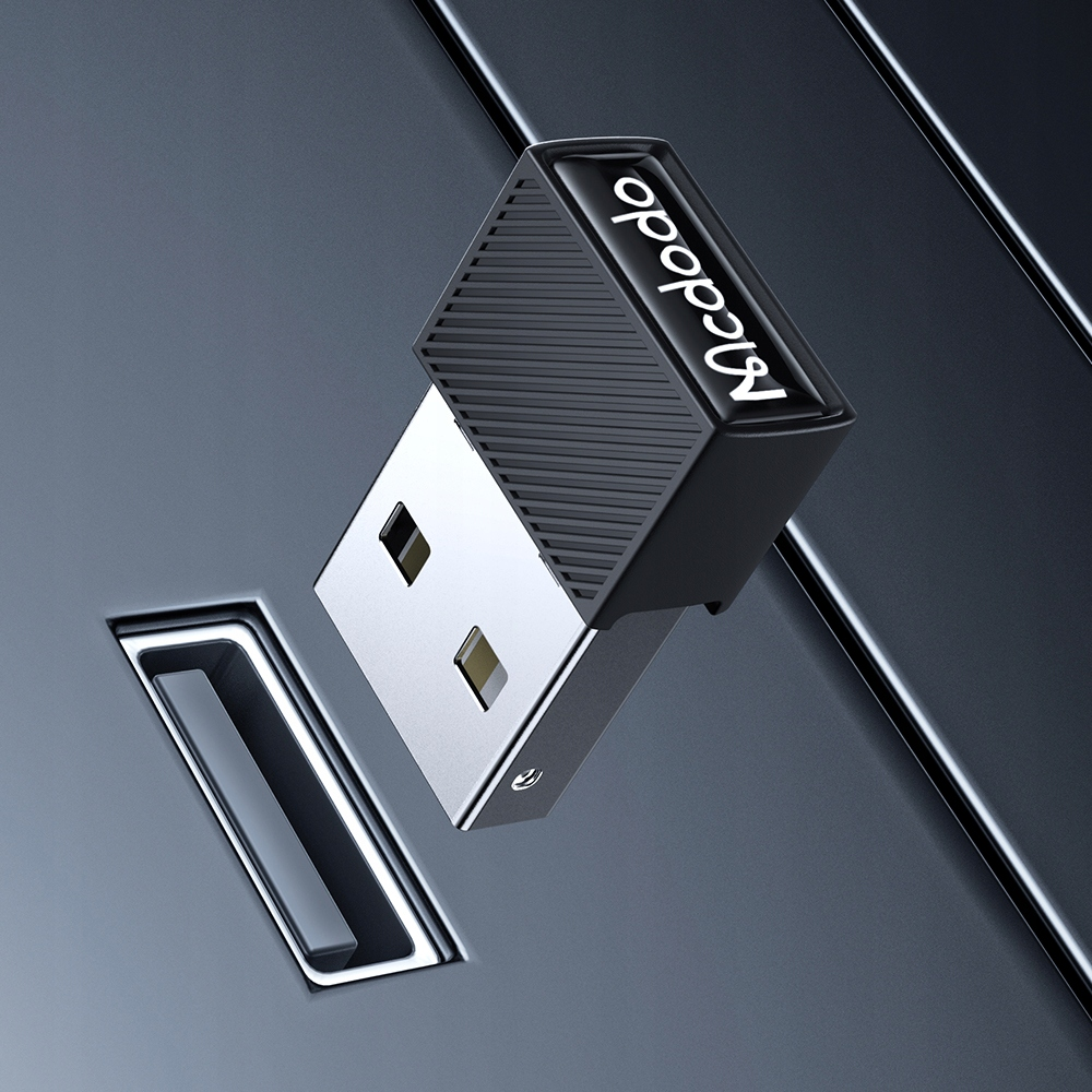 Un adattatore USB Mcdodo fluttua diagonalmente sopra una porta USB su una superficie liscia e scura.