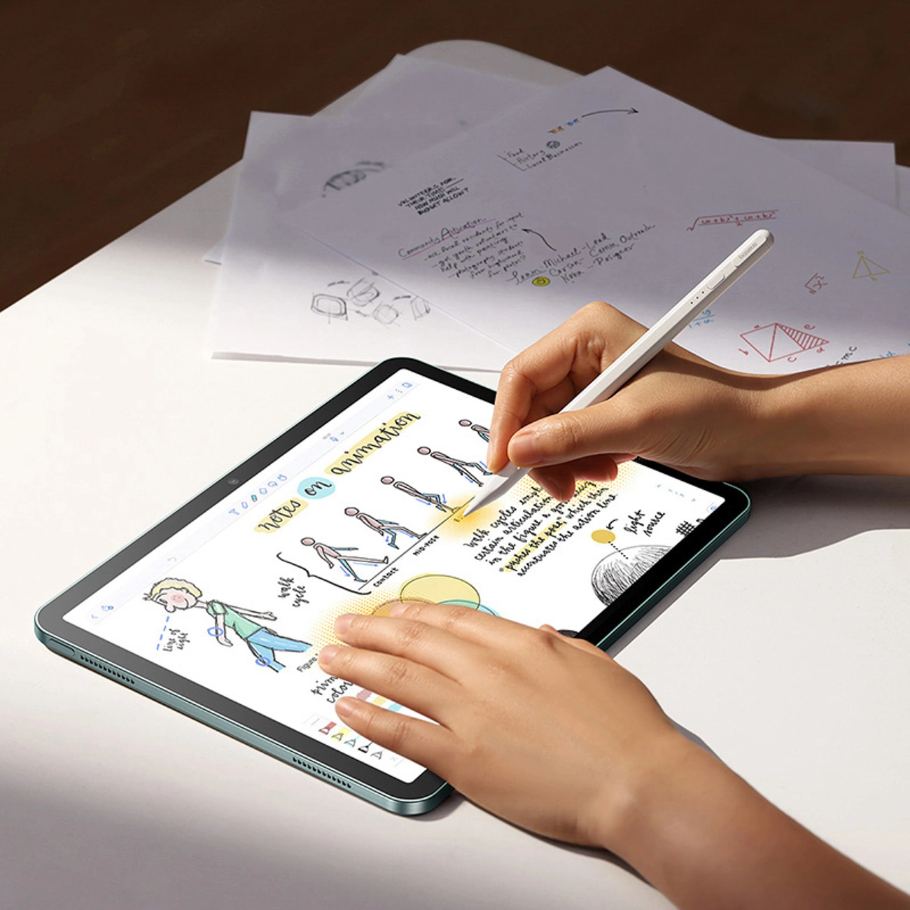 Persona che disegna con uno stilo su un tablet con note di animazione.