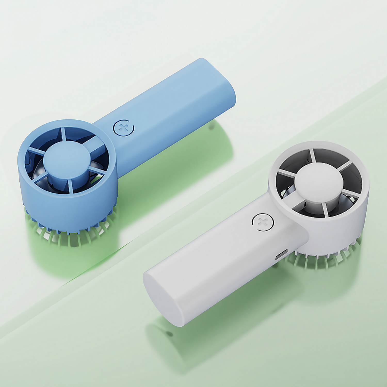 Dos ventiladores eléctricos portátiles de mano, uno azul y otro blanco, sobre una superficie verde claro.