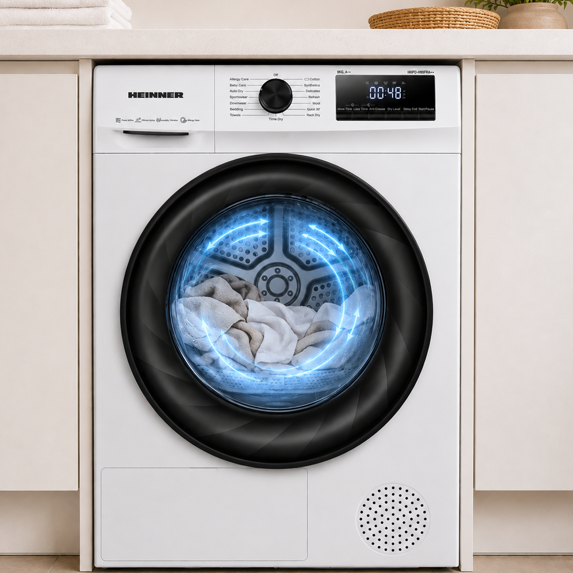 Ein weißer Heinner-Trockner mit Wäsche und leuchtend blauen Kreisgrafiken auf der Glastür.