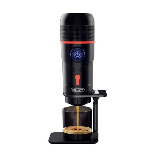 Una caffettiera portatile nera con dettagli rossi versa l'espresso in una tazzina.