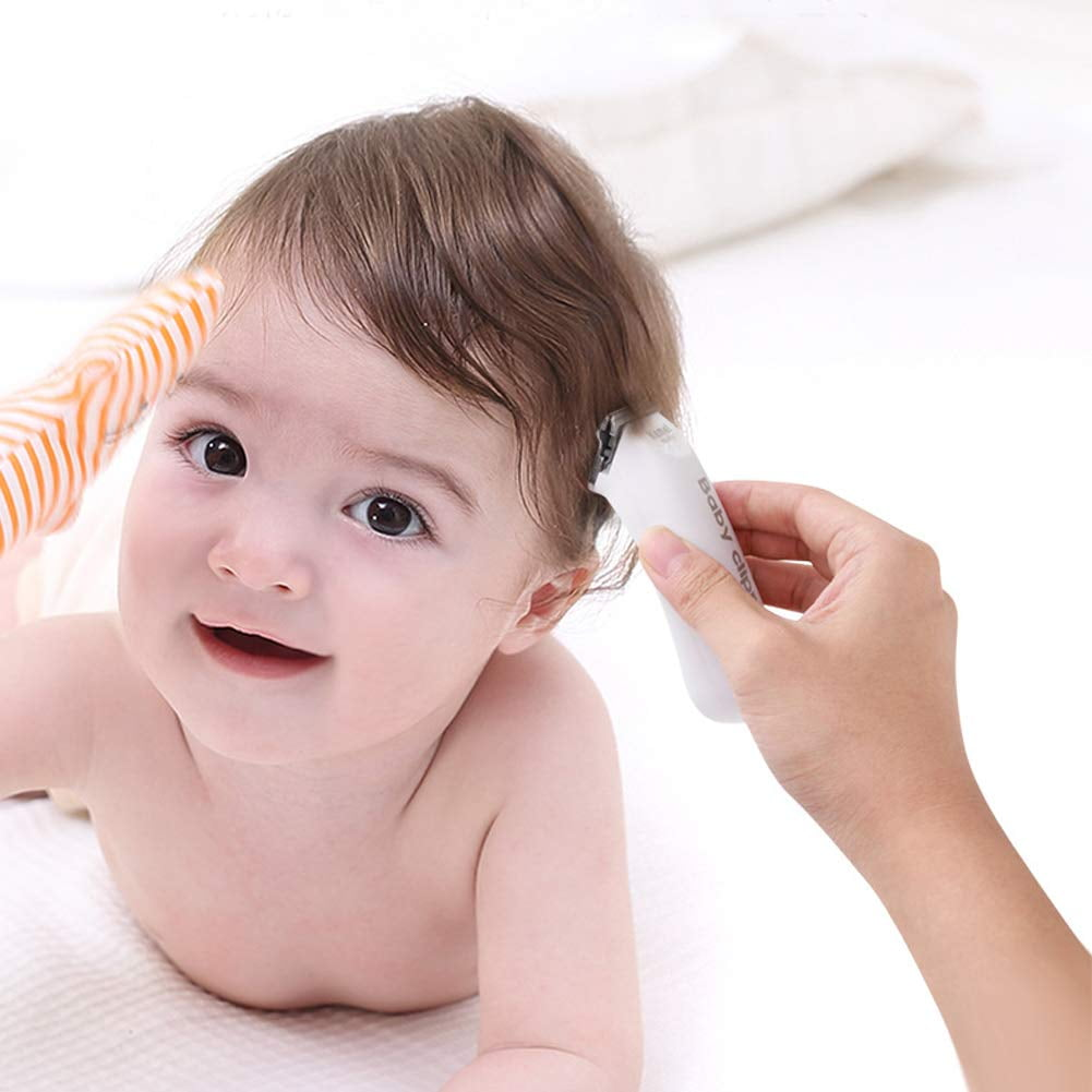 Eine Hand schneidet das Haar eines lächelnden Babys mit einem kleinen weißen Trimmer.
