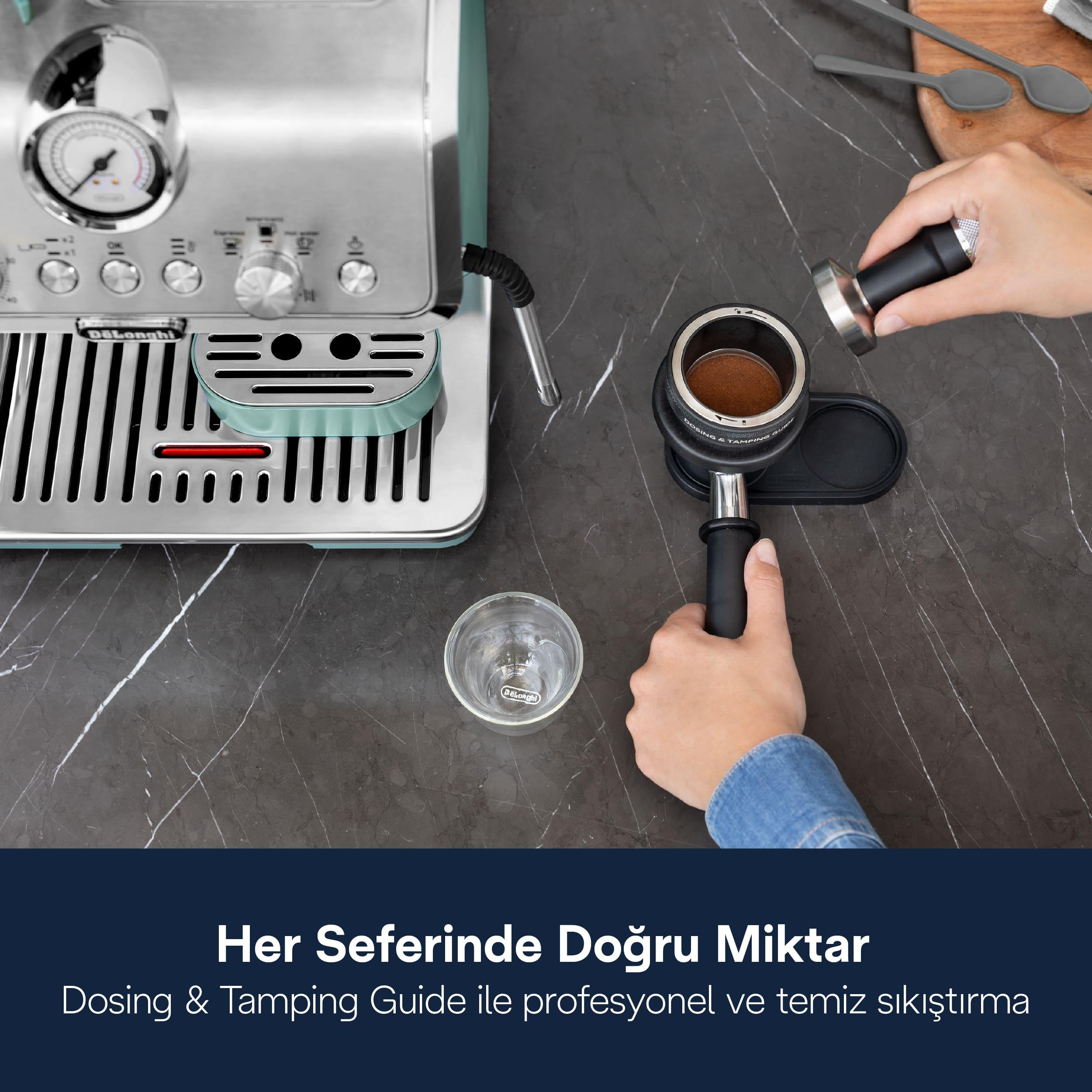 Bir kişi koyu tezgah üzerinde espresso makinesinin yanında portafiltreye kahve sıkıştırıyor.