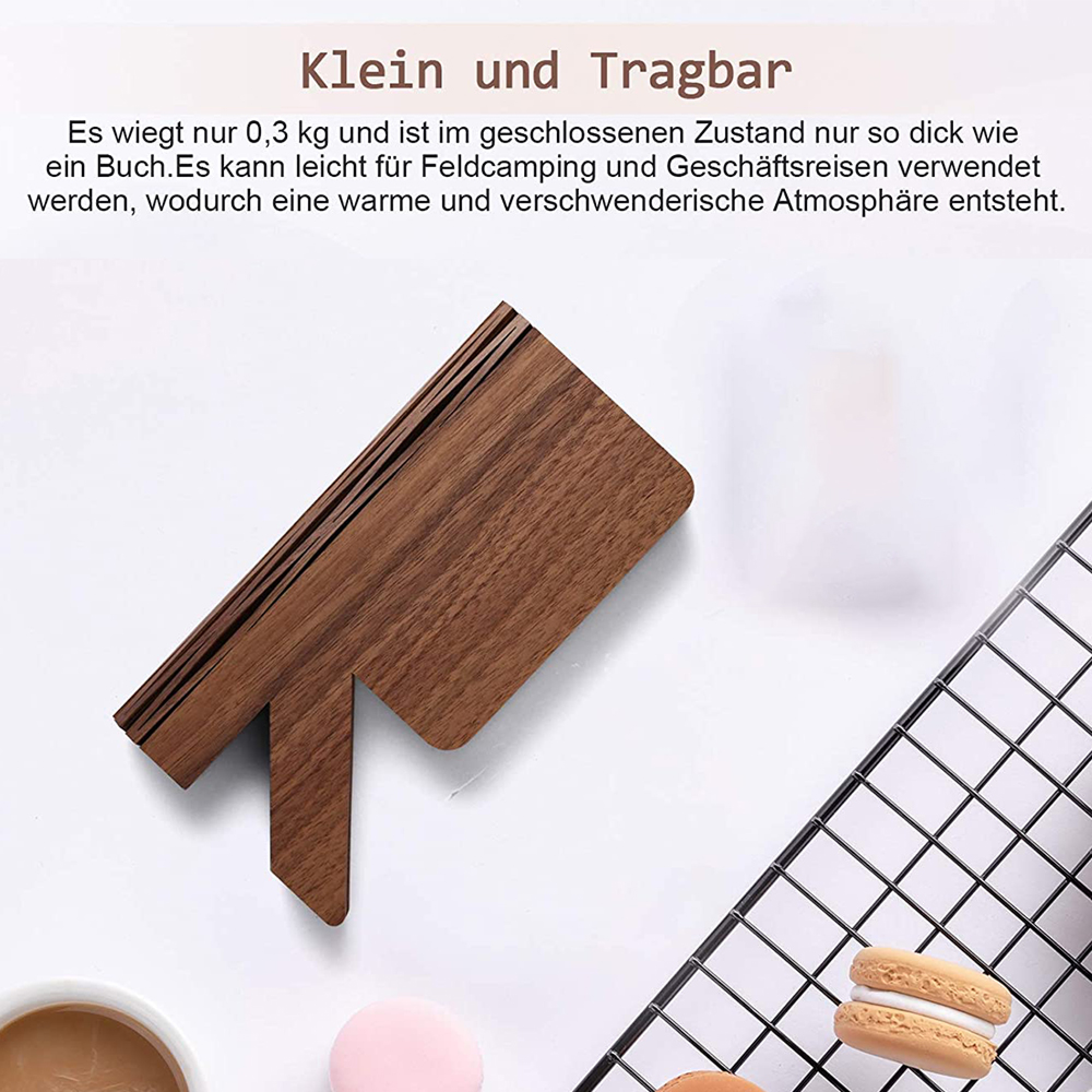 Ein faltbarer Holzständer auf einem Tisch mit Macarons und einer Kaffeetasse.