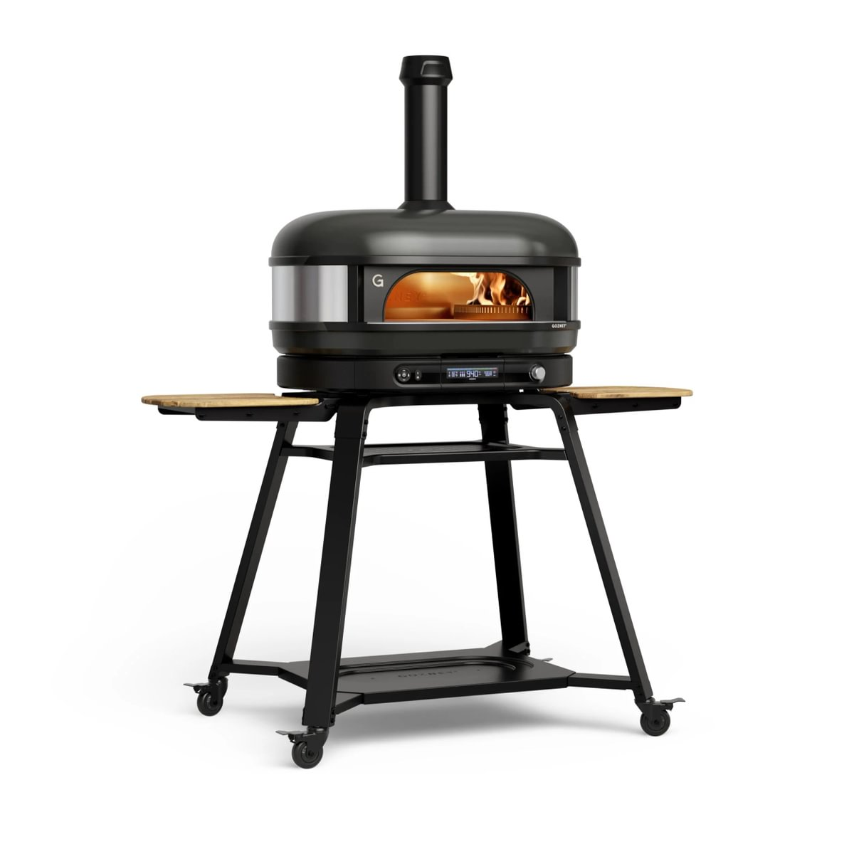 Ein schwarzer Pizzaofen auf einem fahrbaren Metalltisch mit Holzeinlagen, innen brennt ein Feuer.