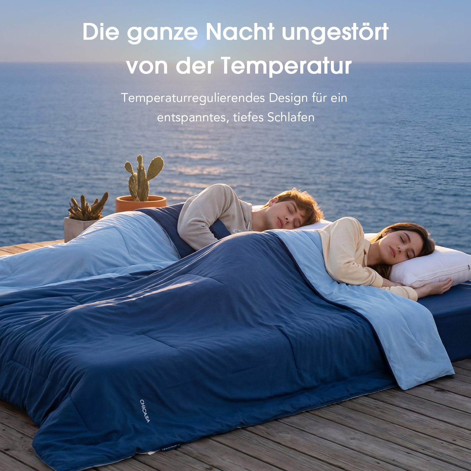 Zwei Personen schlafen entspannt auf einem Bett im Freien vor dem Meer.