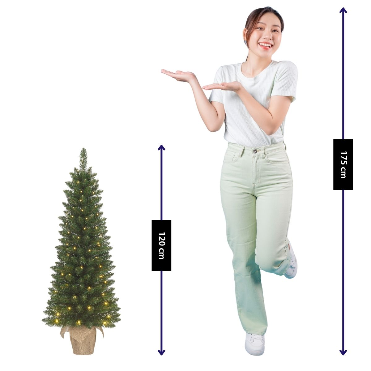 Eine Frau in weißem Shirt zeigt auf einen 120 cm großen Weihnachtsbaum neben ihr.