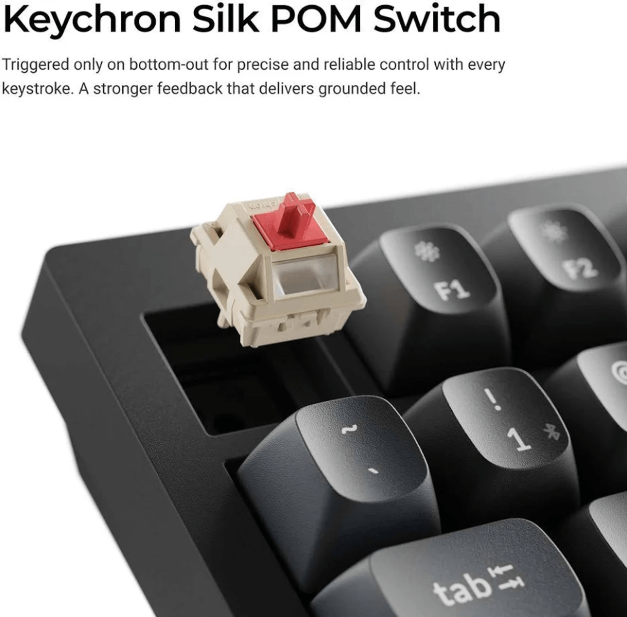 Beżowo-czerwony przełącznik mechaniczny Keychron Silk POM unosi się nad pustym gniazdem na czarnej klawiaturze.