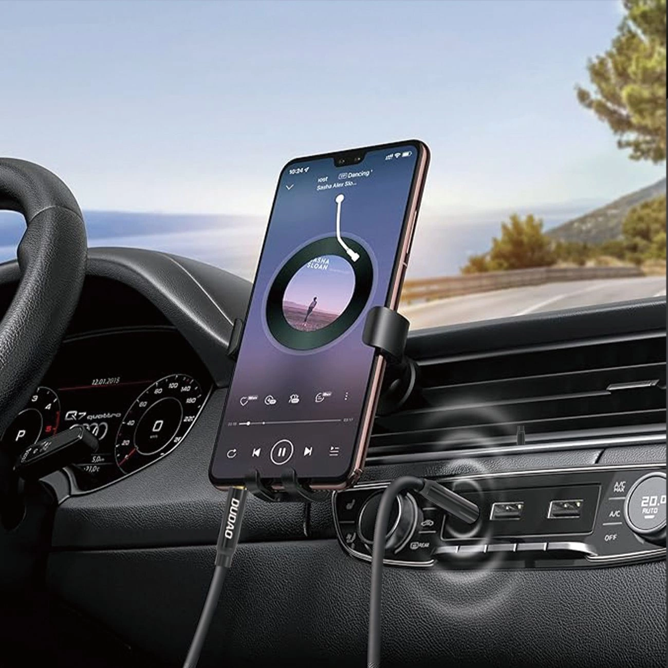 Smartphone in un supporto per auto sul cruscotto, collegato con cavi USB, con vista su una strada.