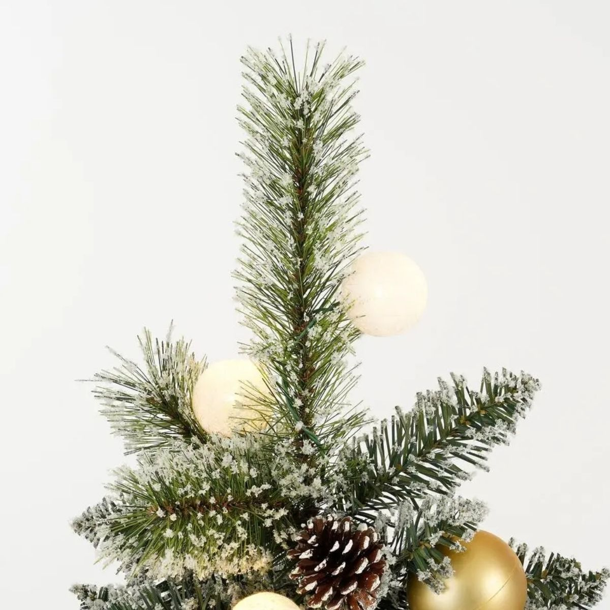 Verschneiter Weihnachtsbaum mit Zapfen und Kugeln auf weißem Grund.