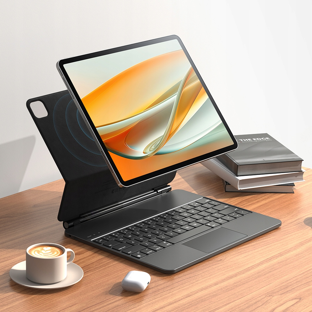 Un tablet con tastiera, tazza di caffè e auricolari su una scrivania in legno.