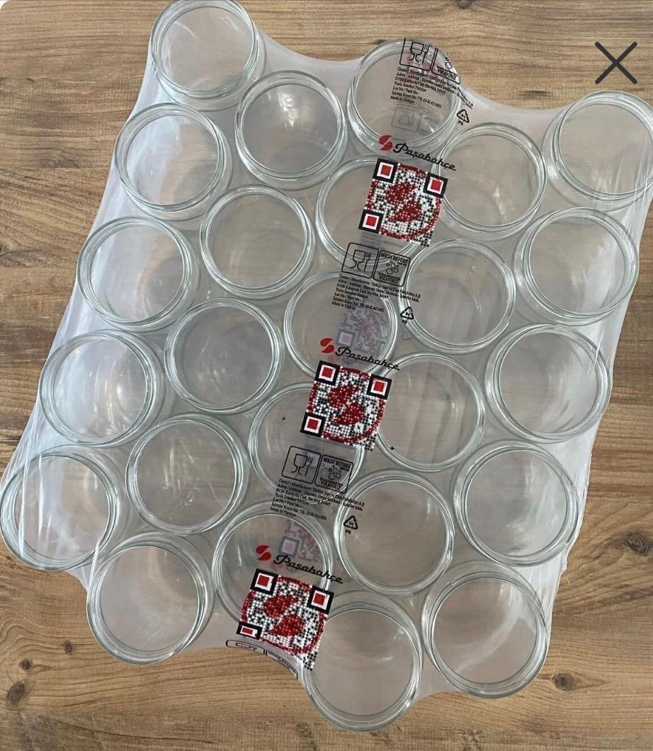 Ahşap üzerinde plastik filme sarılı boş cam kavanoz paketi.