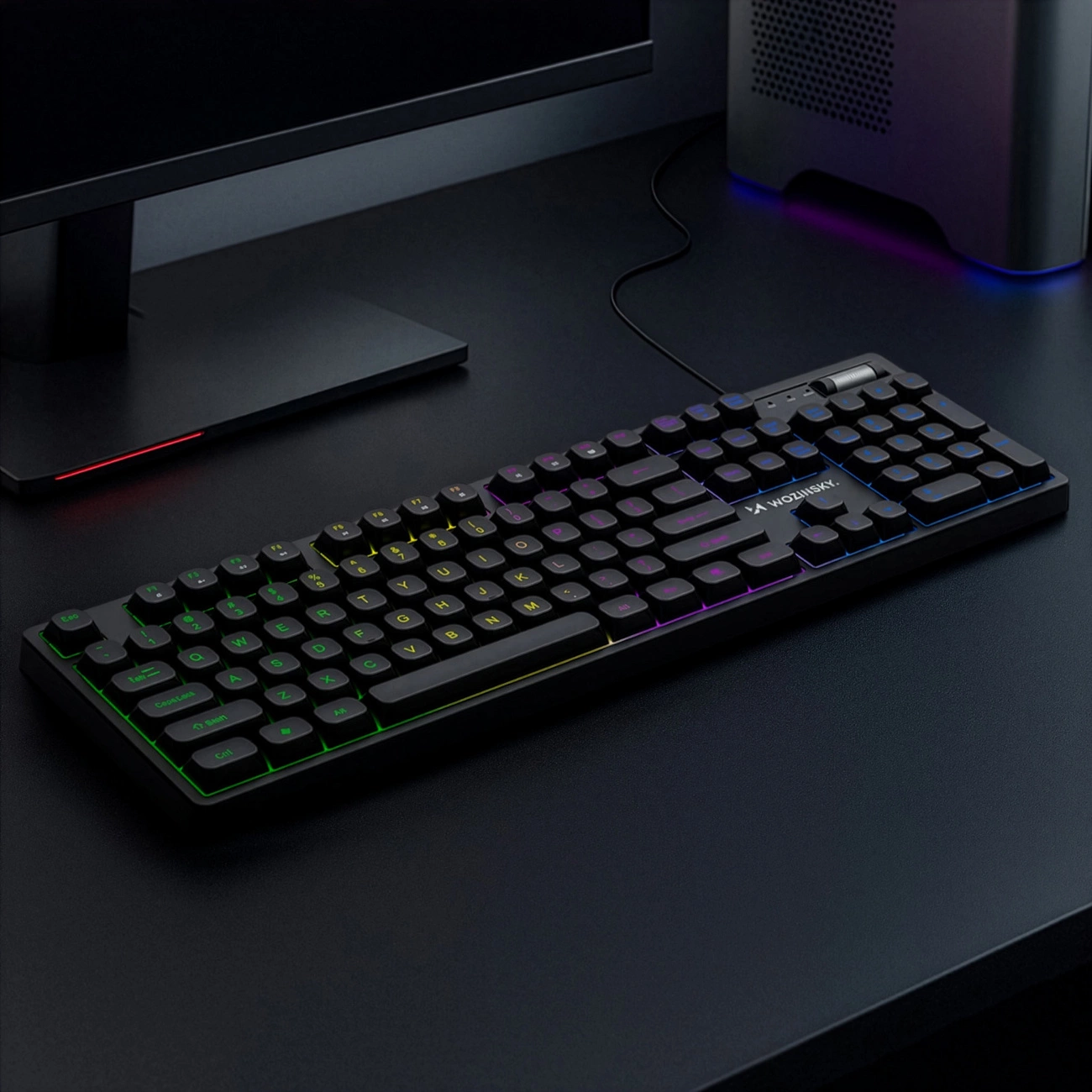 Una tastiera meccanica nera con retroilluminazione RGB si trova su una scrivania vicino a un monitor.