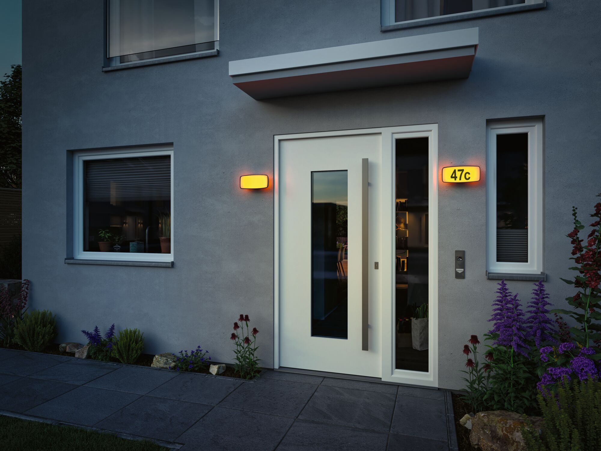 Moderne graue Haustür mit weißem Rahmen, beleuchteter Hausnummer 47c und Wandleuchte bei Dämmerung.