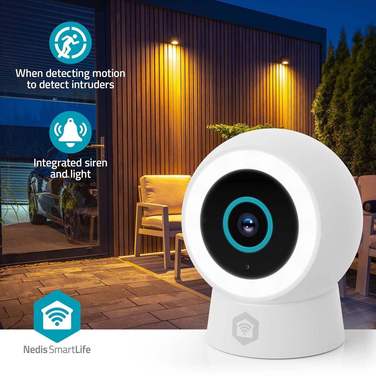 Une caméra de sécurité intelligente blanche se trouve sur une terrasse devant une maison en bois illuminée.