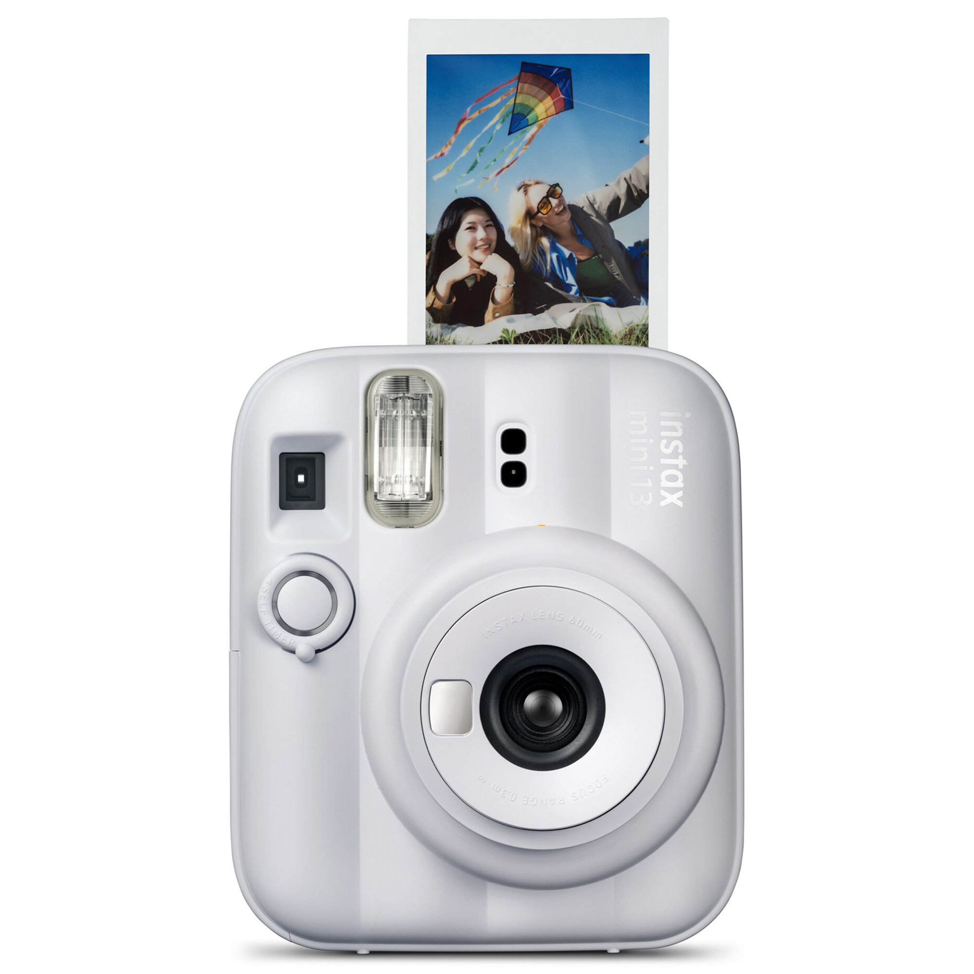 Beyaz bir Instax Mini 12 kamera, uçurtmalı iki gülen kadının fotoğrafını basıyor.